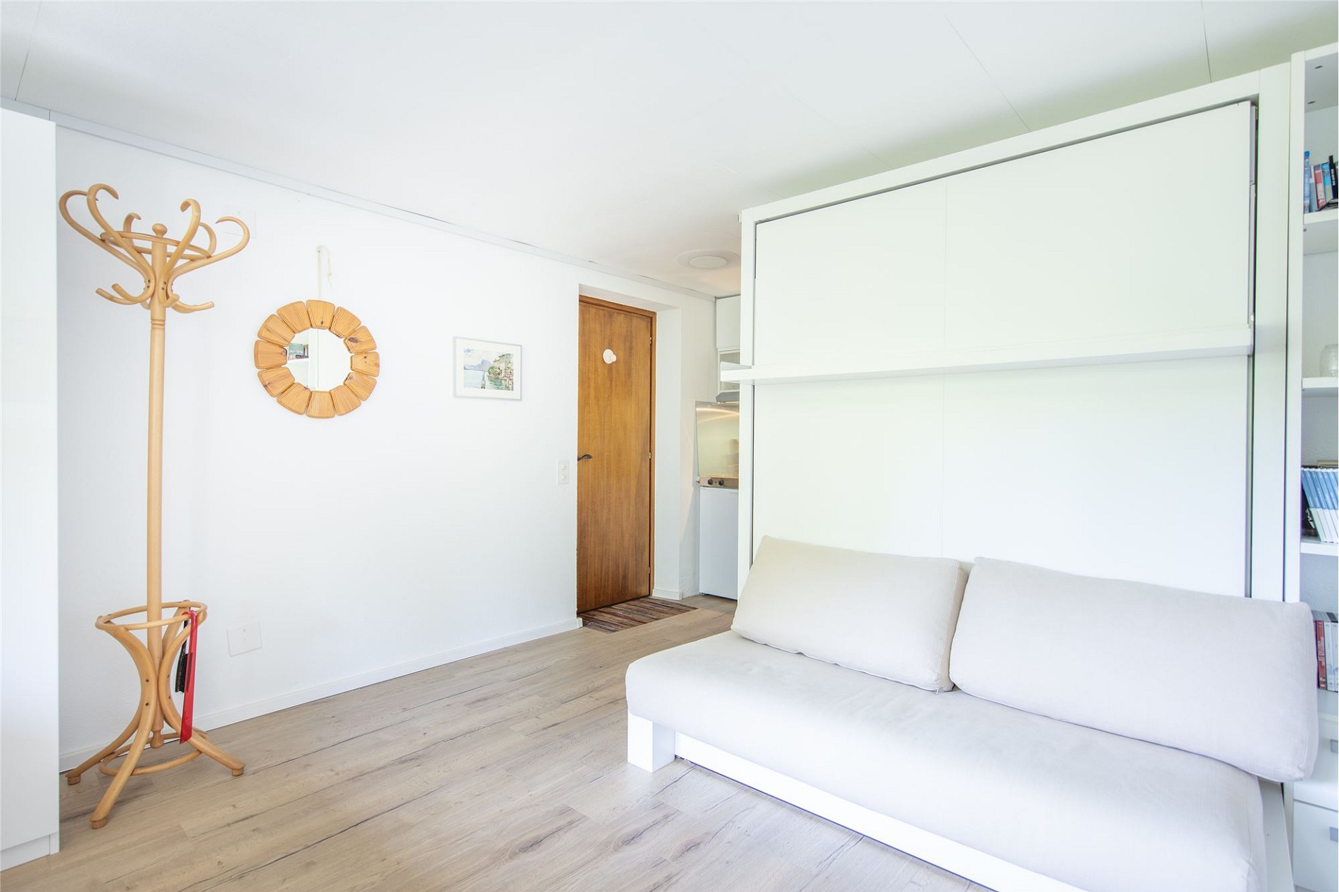 Helles Schlafzimmer mit Klappsofa und Schrankwand