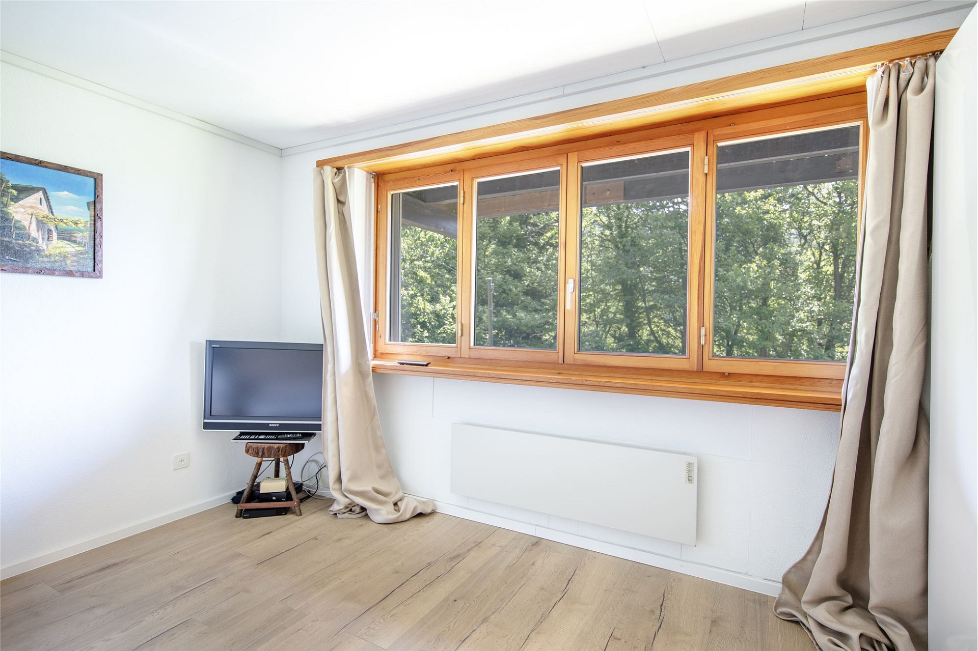Helles Zimmer mit großem Holzfenster