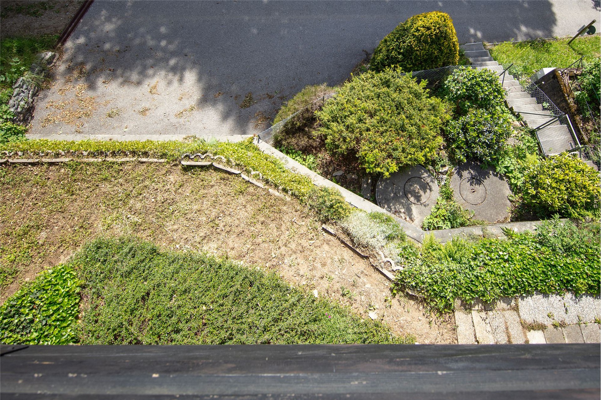 Außenansicht eines Gartens mit Zufahrt und Treppen