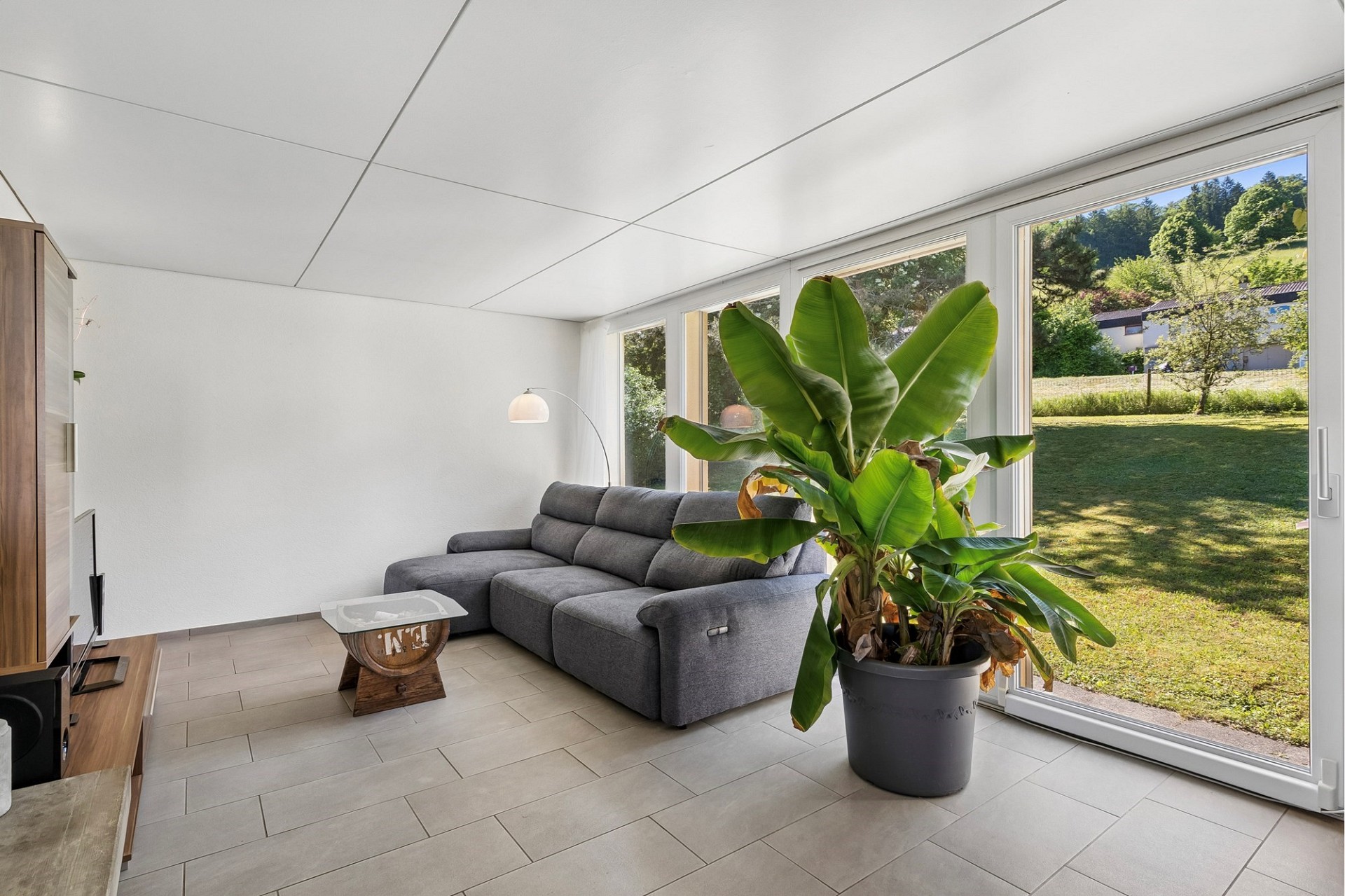 Helles Wohnzimmer mit großem Fenster zur Wiese