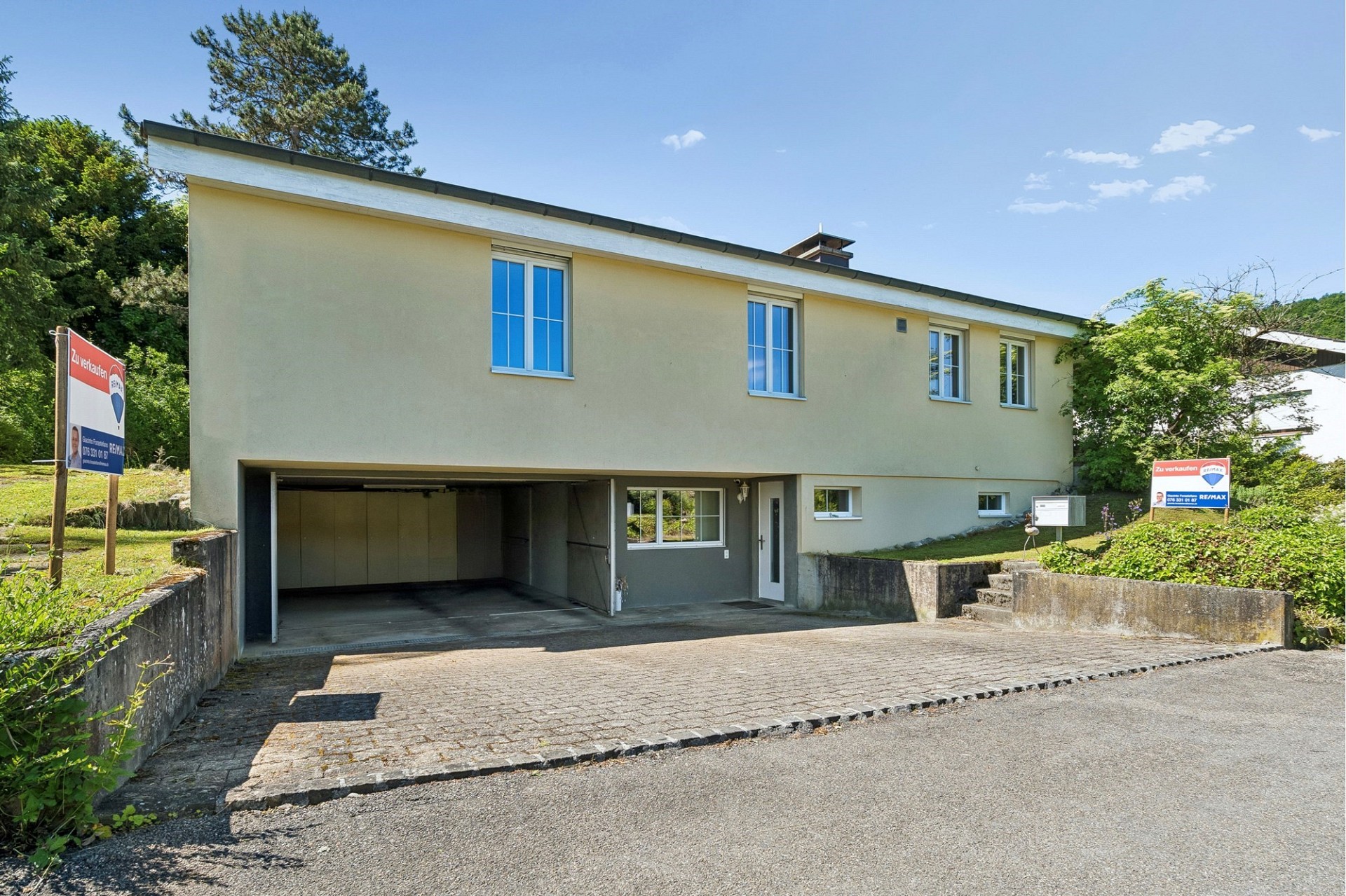 Freistehendes Haus mit Garage und Verkaufsschildern