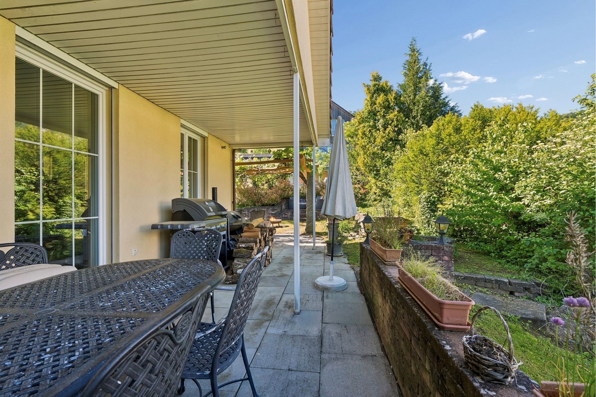 Überdachte Terrasse mit Gartenblick
