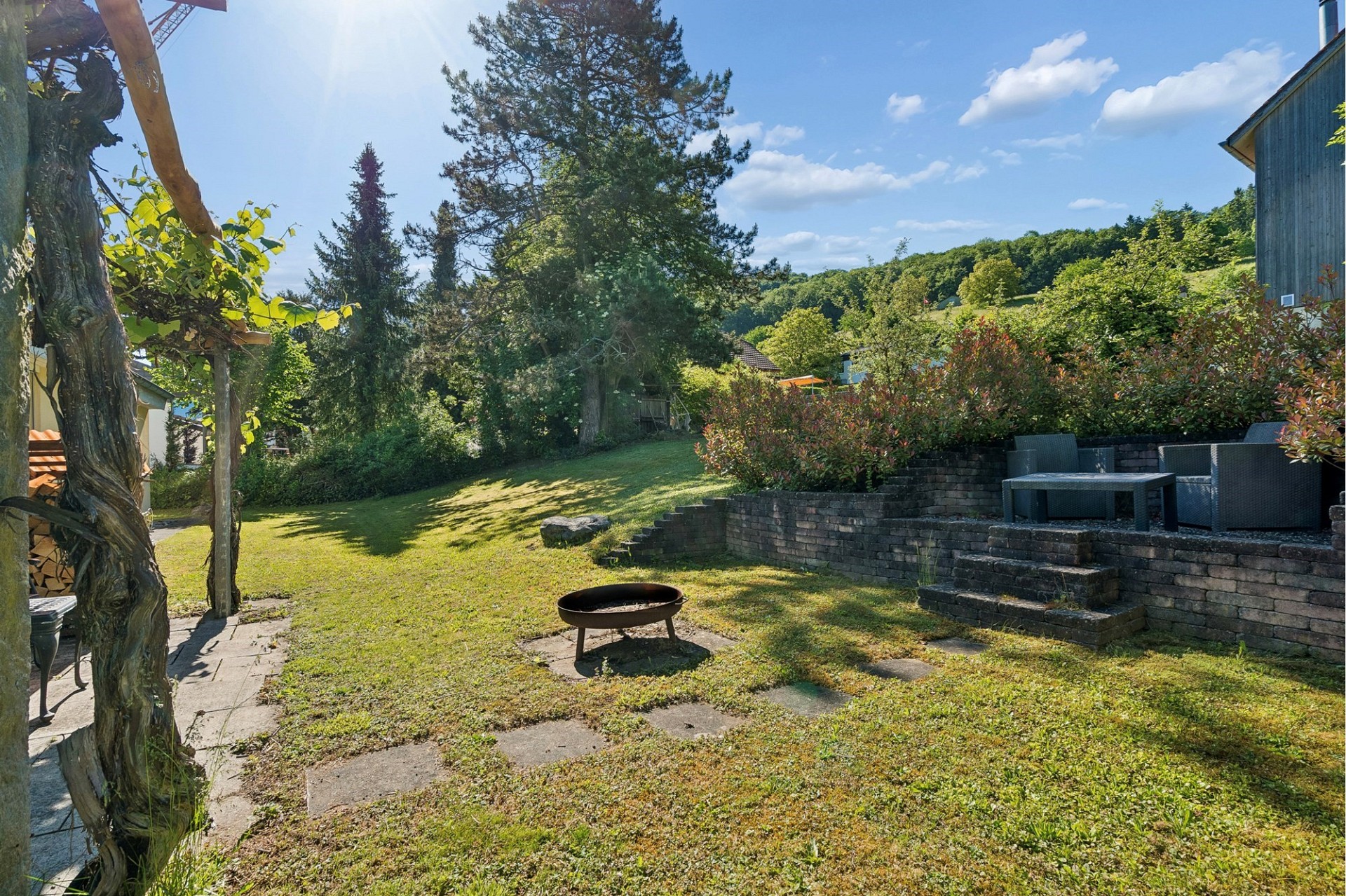 Großer Garten mit Sitzbereich und Feuerstelle