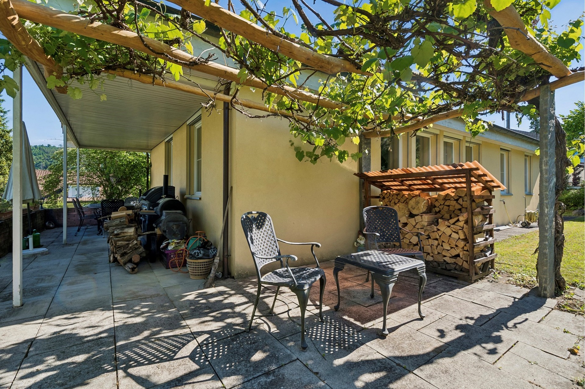 Terrasse mit Sitzbereich und Holzlager