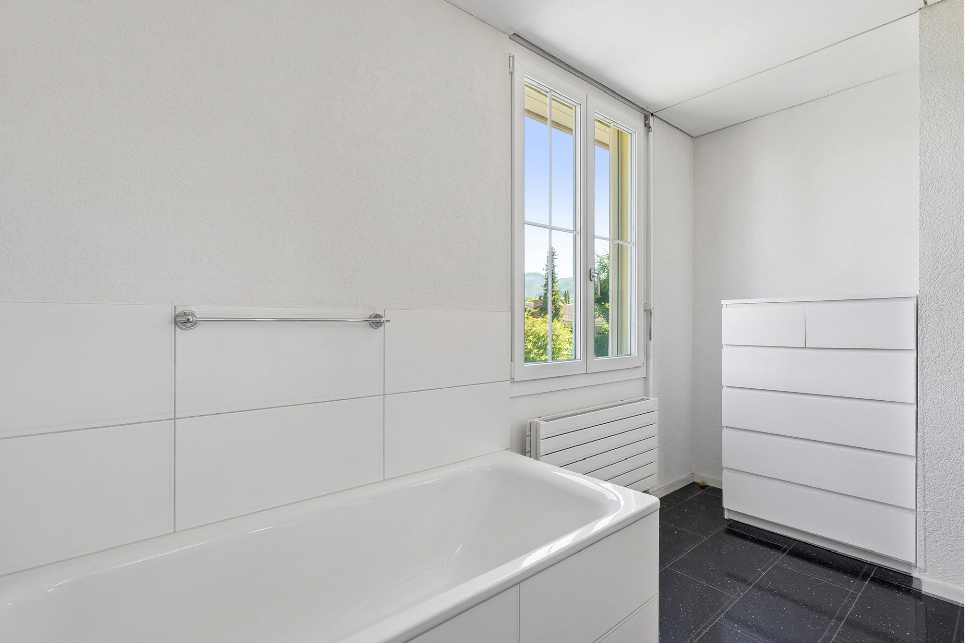 Helles Badezimmer mit Badewanne und Fenster