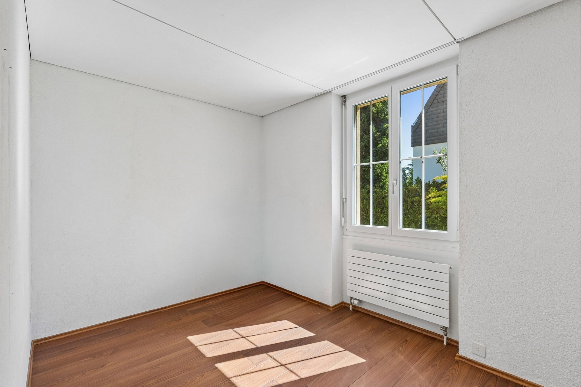 Leerer heller Raum mit Fenster und Heizkörper