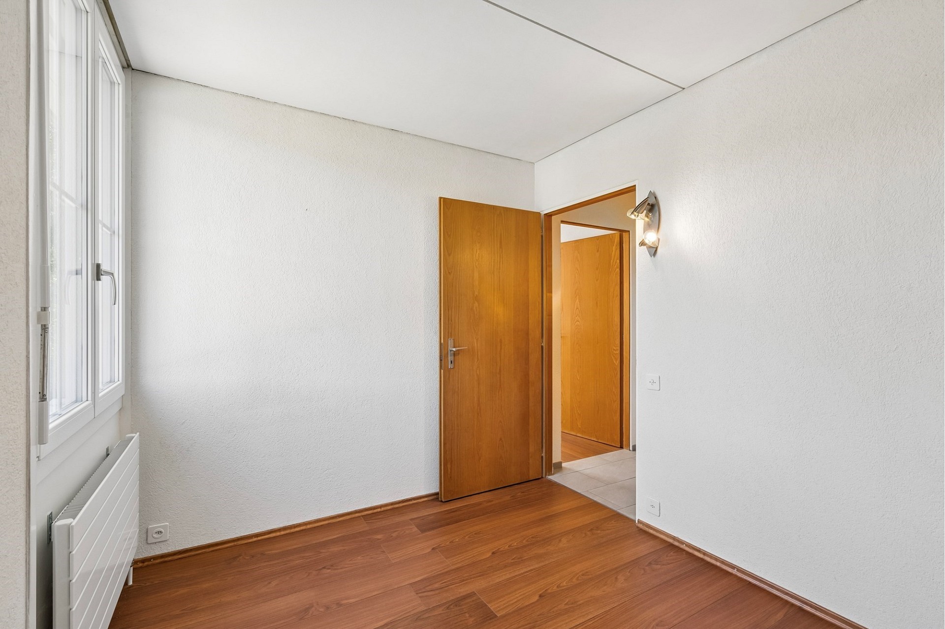 Heller leerer Raum mit Holzboden und Innentüren