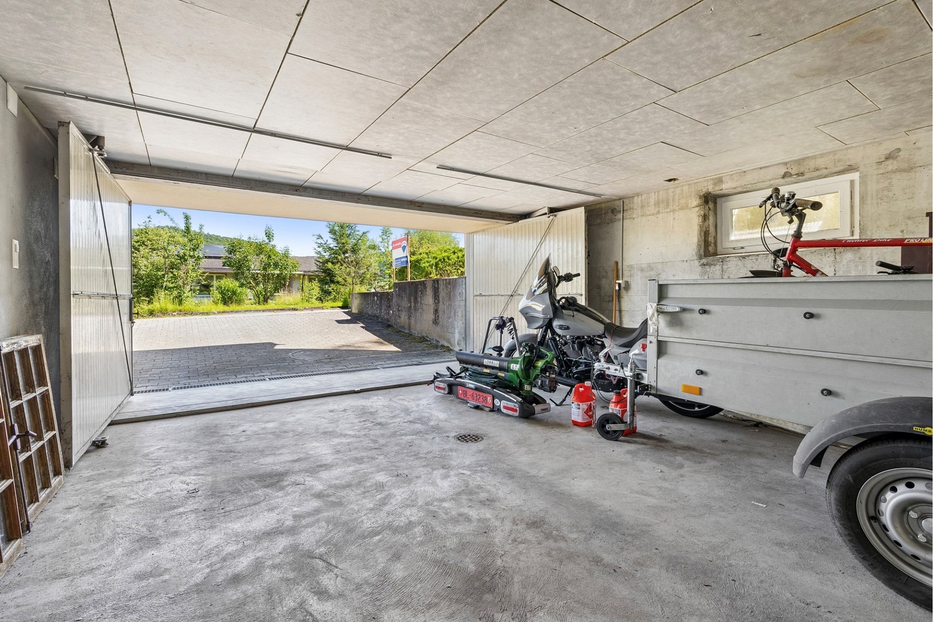 Garage mit geöffnetem Tor und Blick nach draußen