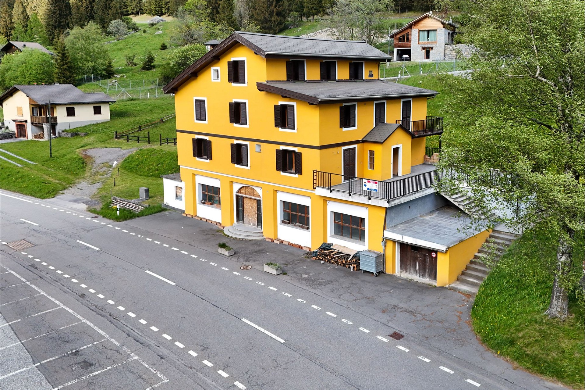 Gelbes Mehrfamilienhaus in alpiner Hanglage