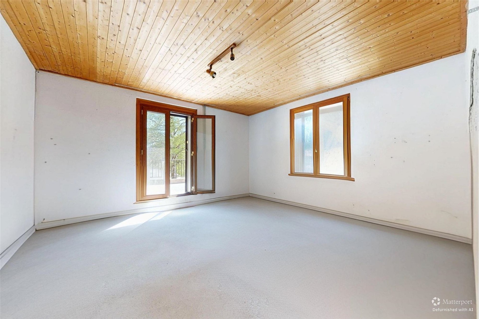 Leerer Raum mit Holzdecke und Fenstern