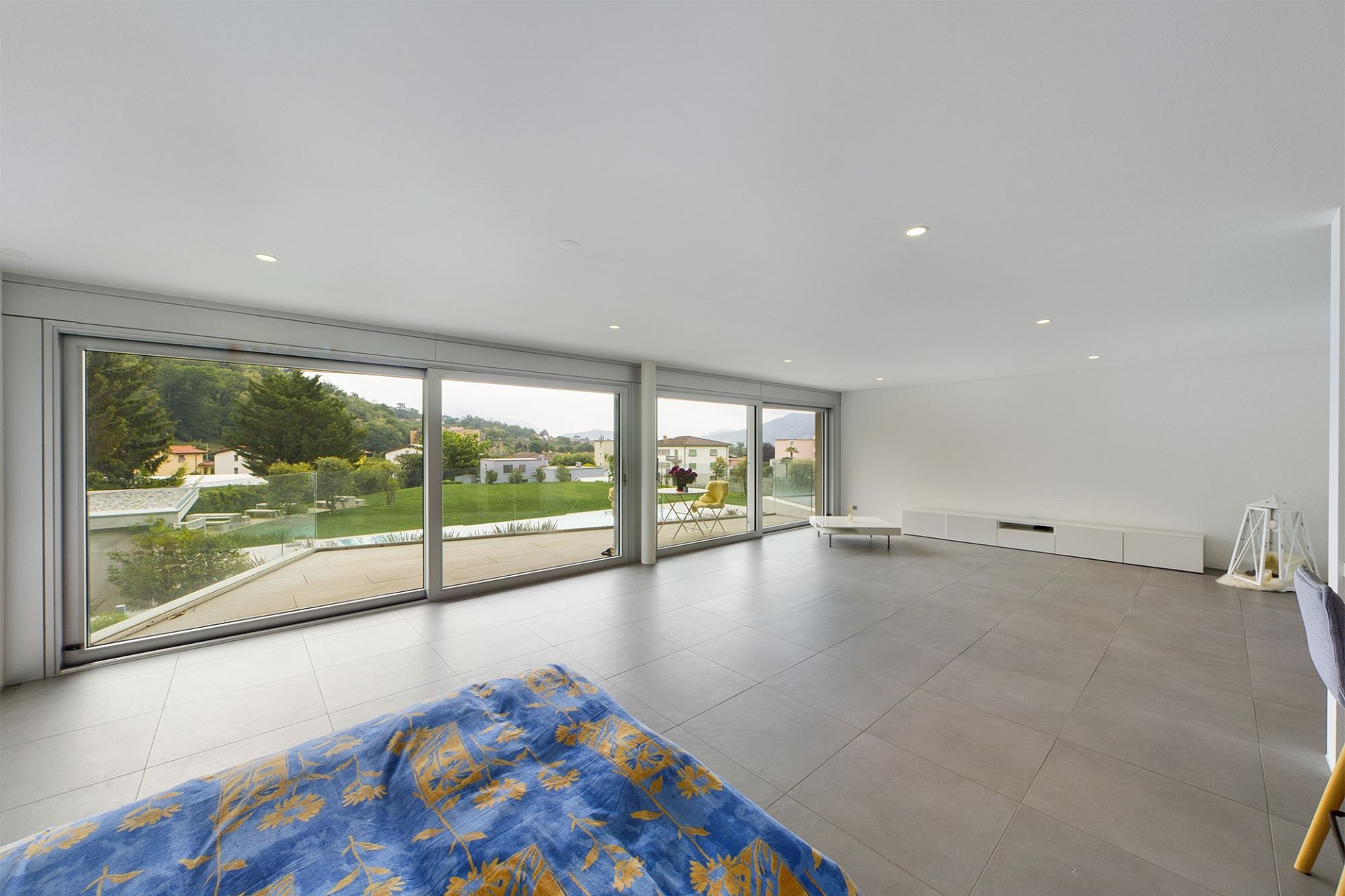 Großer, modern gestalteter Wohnraum mit Panoramafenstern und Gartenblick