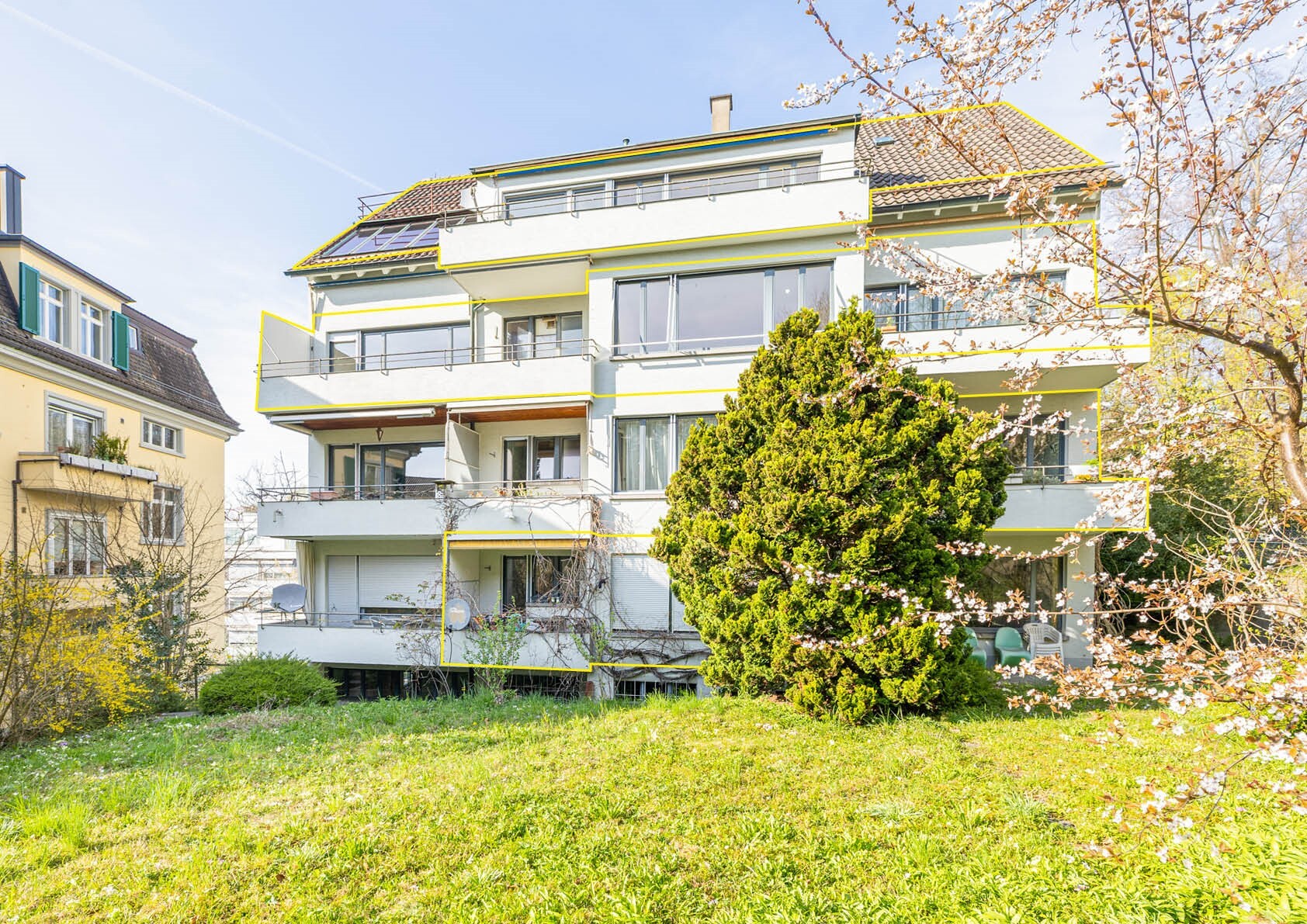 Mehrfamilienhaus mit Balkonen und Gartenansicht