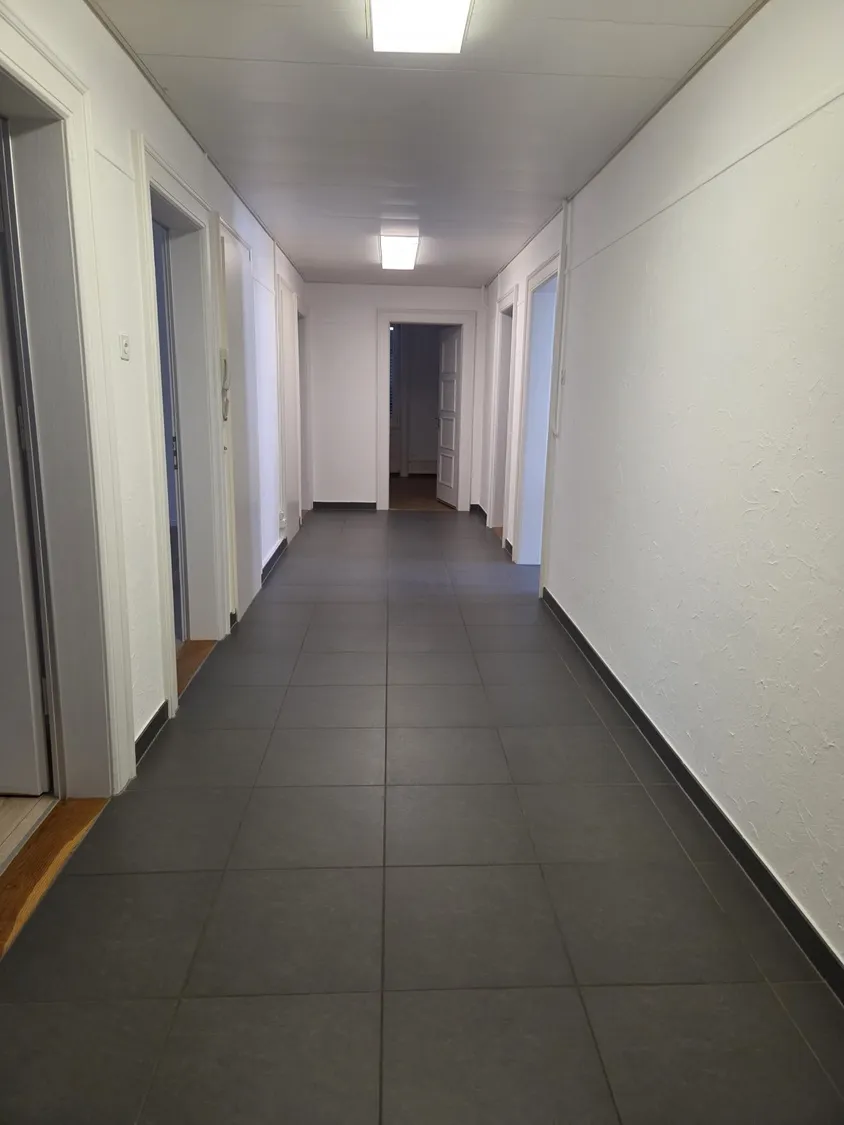 Langer Flur mit dunklem Fliesenboden