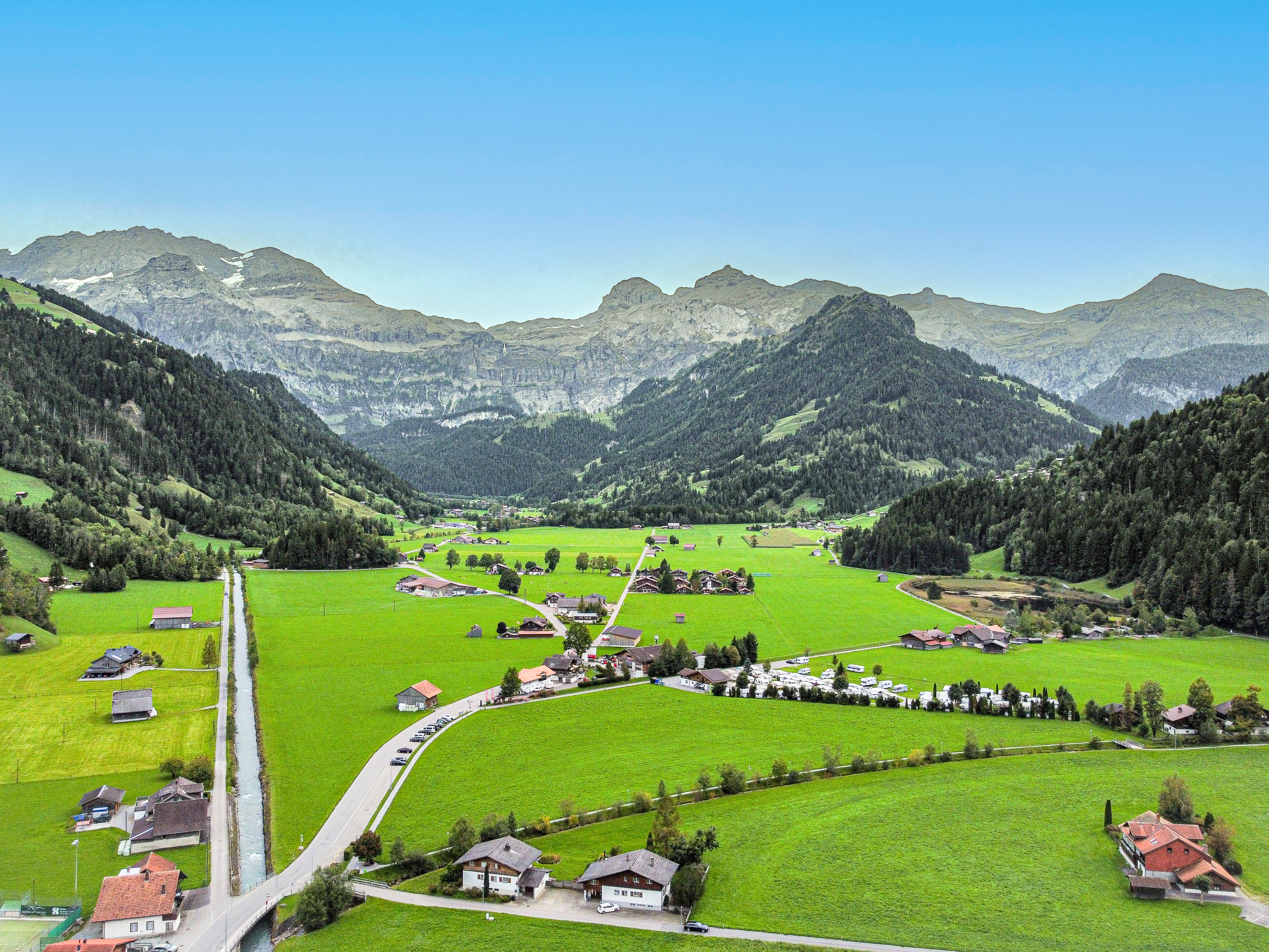 Alpenlandschaft mit Tal, Wiesen und Bergen
