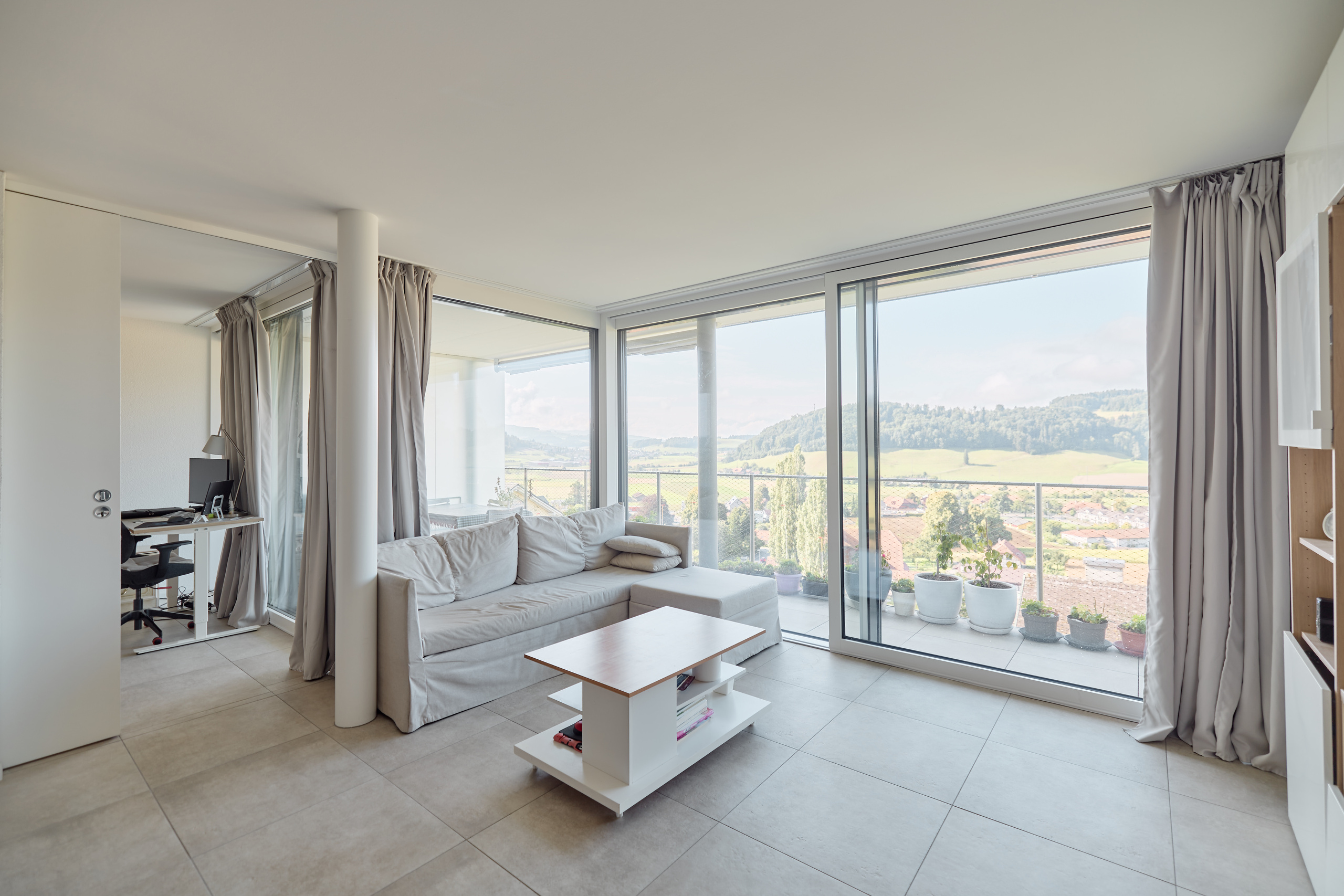 Heller Wohnbereich mit Panoramafenster und Balkonblick