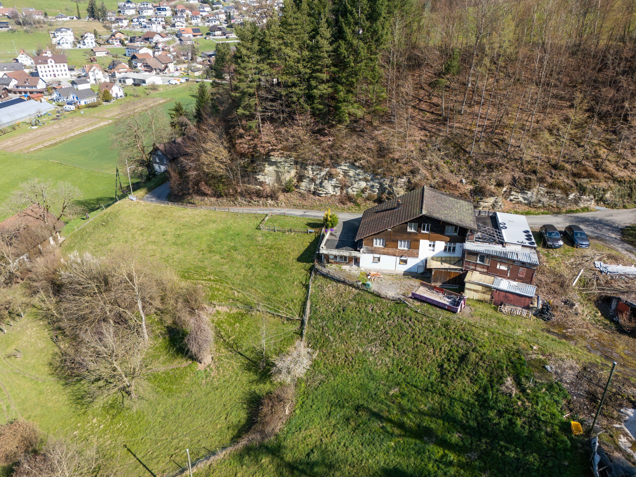 Luftaufnahme eines Hauses am Hang mit großem Grundstück