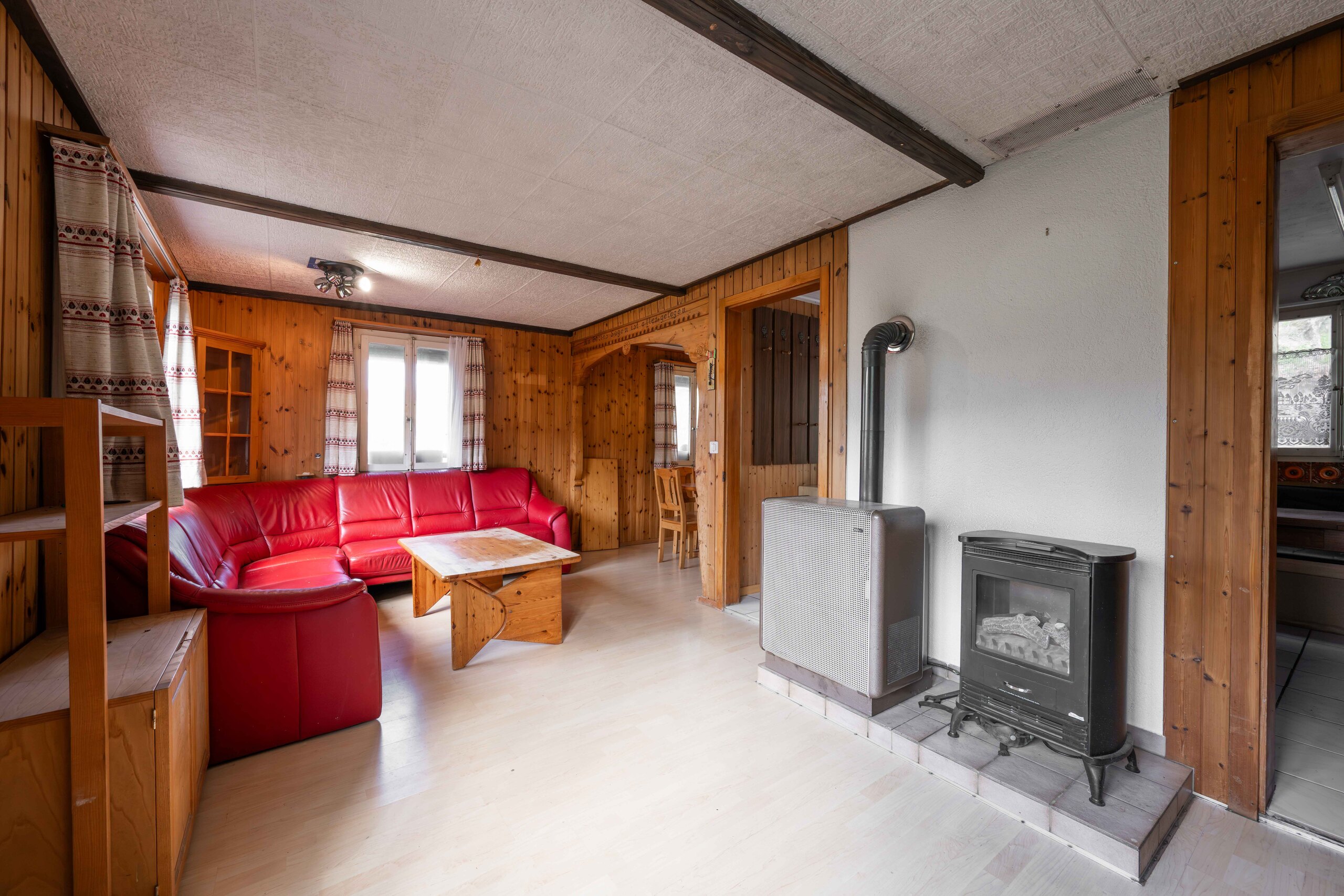 Gemütliches Wohnzimmer mit Holzverkleidung und Kaminofen