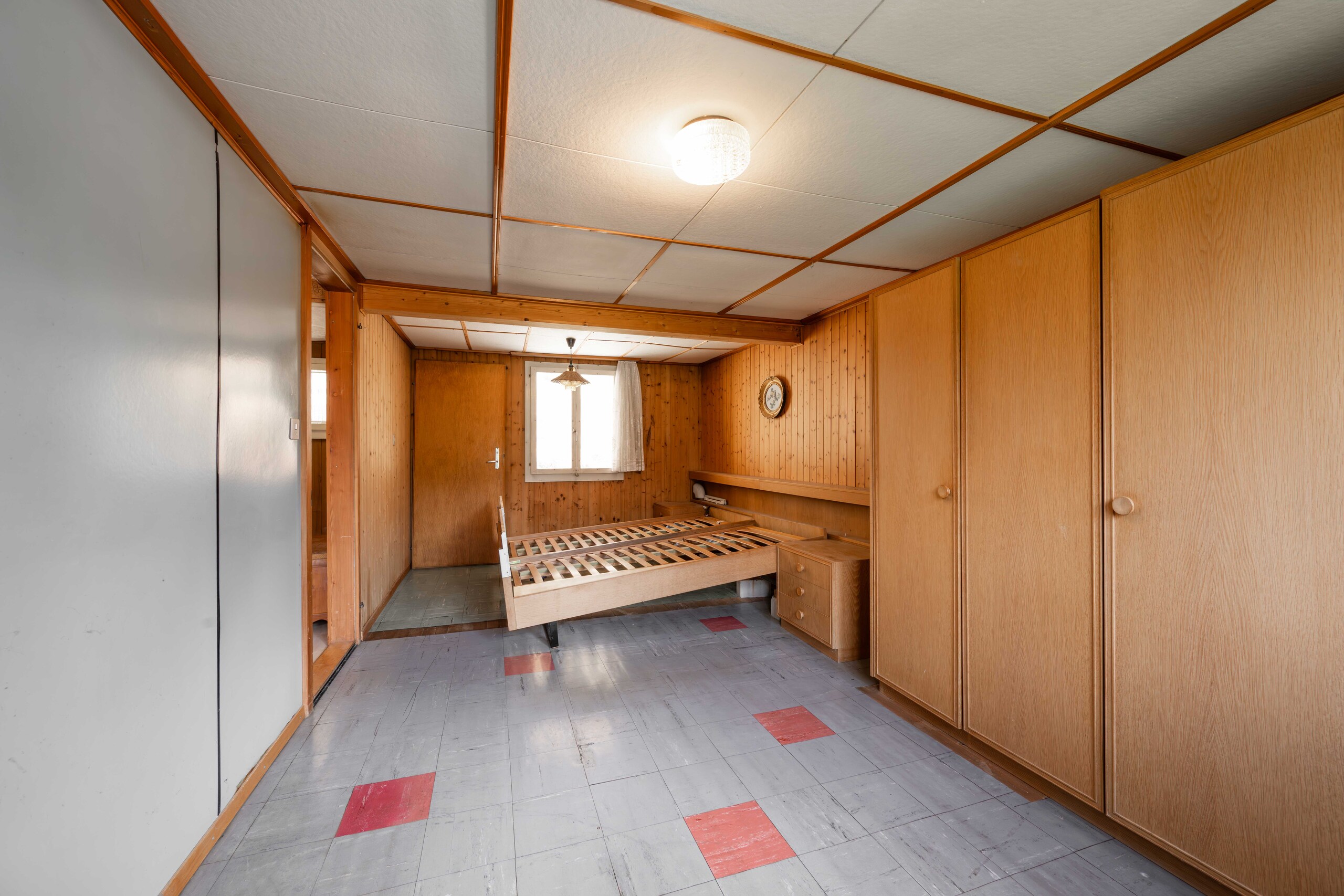 Schlafzimmer mit Holzvertäfelung und Einbauschränken