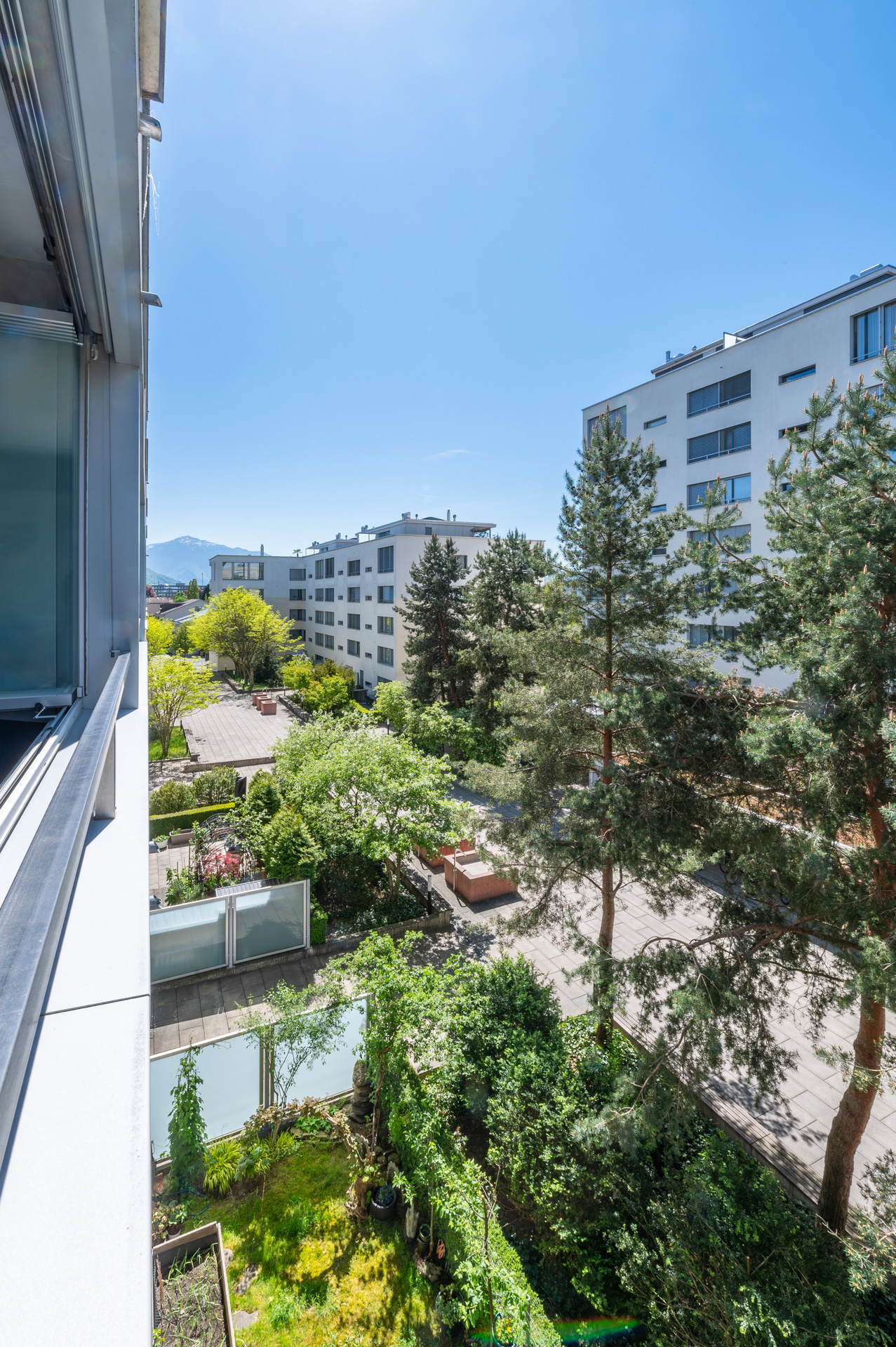 Blick vom Balkon in einen begrünten Innenhof