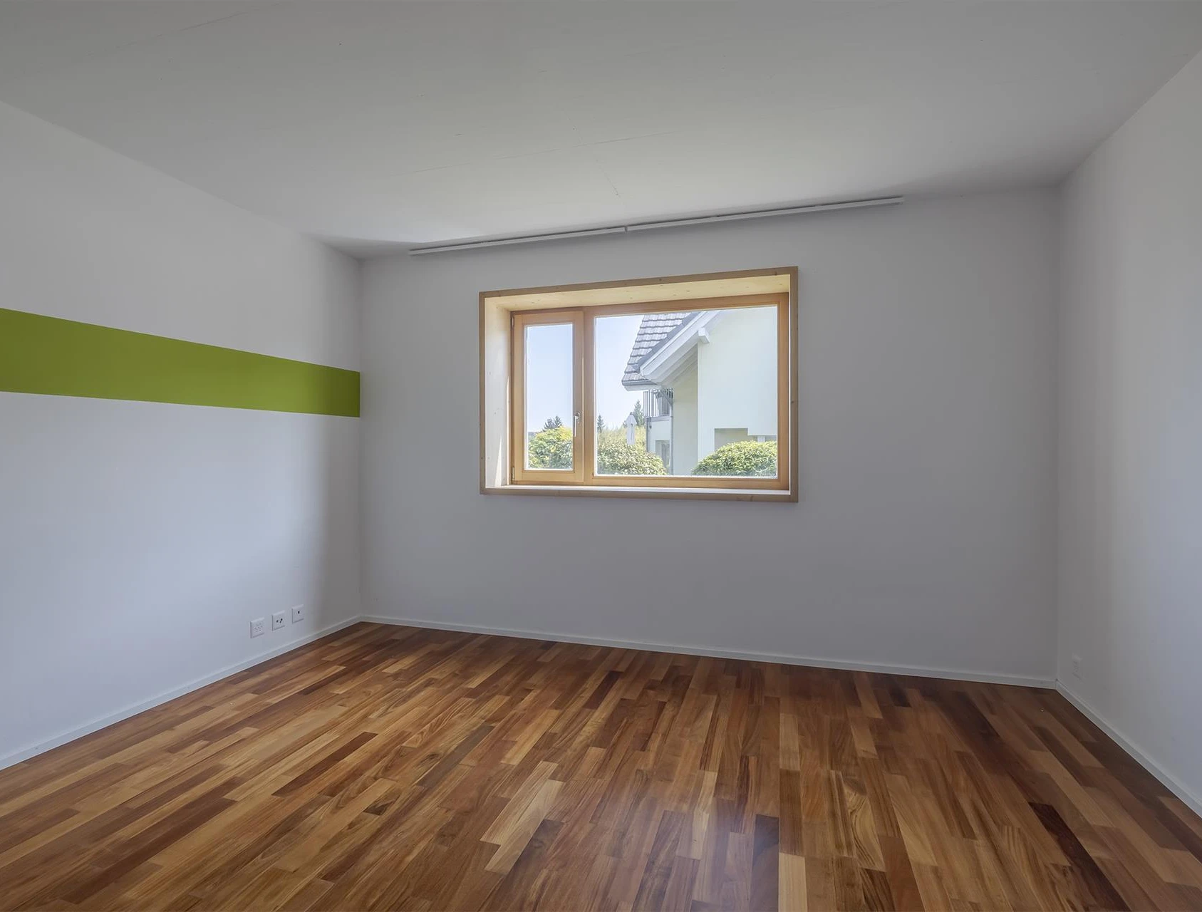 Heller leerer Raum mit Fenster und Holzfußboden