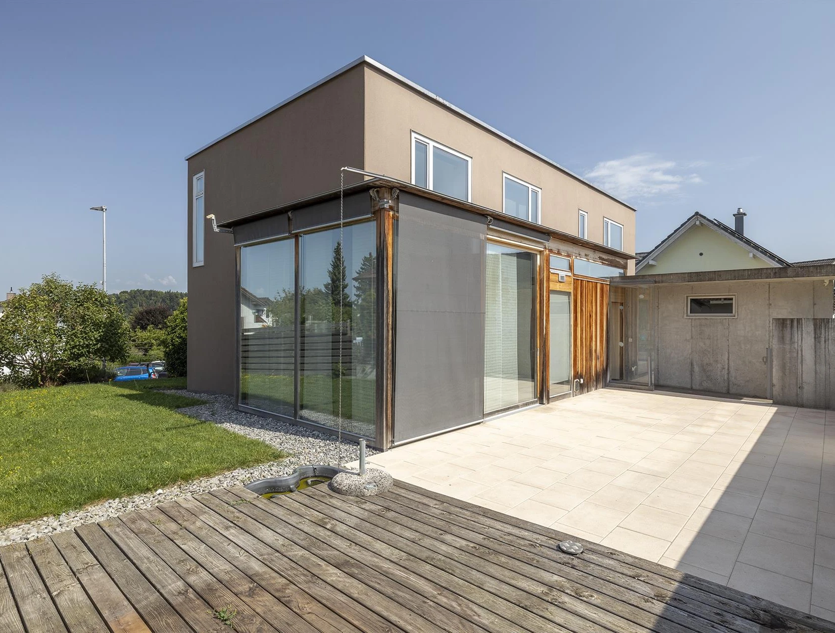 Moderne Terrasse mit Garten und Anbau