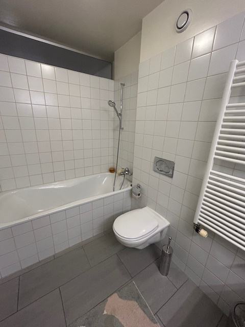 Kleines Badezimmer mit Badewanne und wandhängendem WC