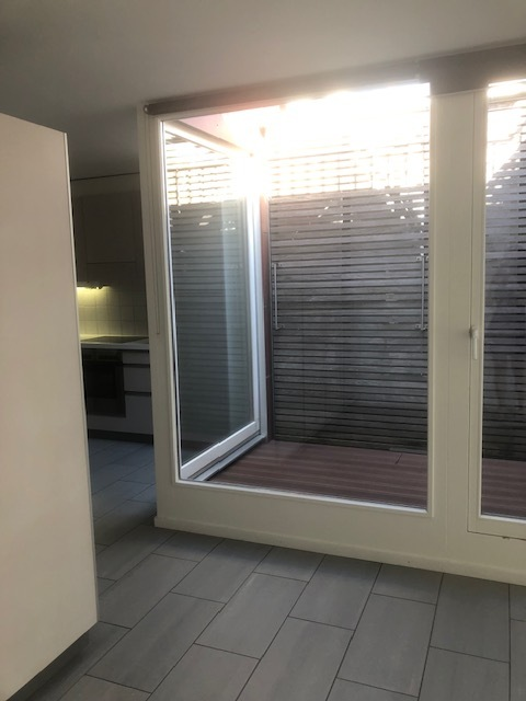 Innenraum mit großer Glasfront zum kleinen Patio