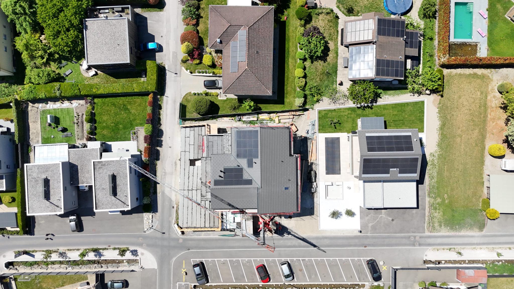 Luftaufnahme eines Wohnquartiers mit Neubau und Solardächern