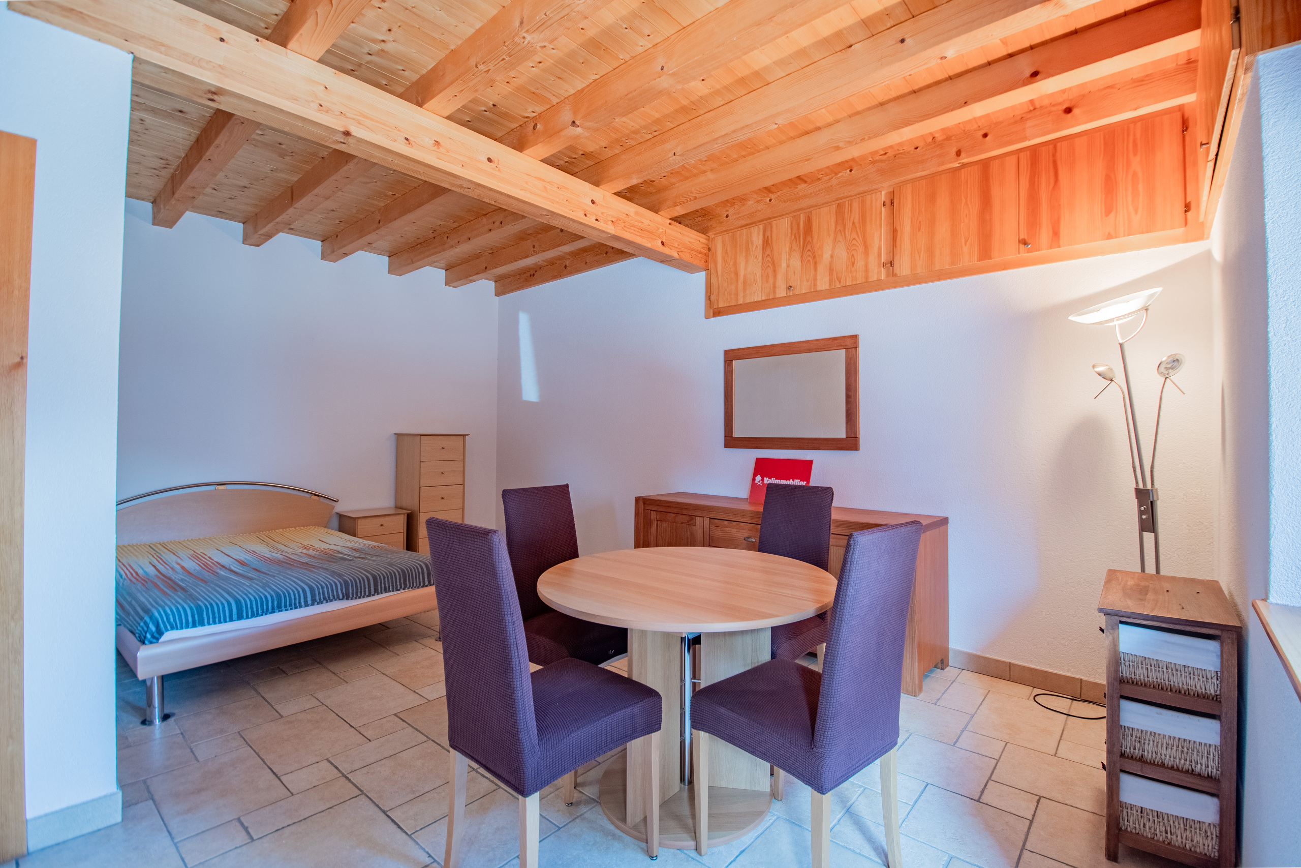 Helles Schlaf- und Esszimmer mit Holzbalkendecke