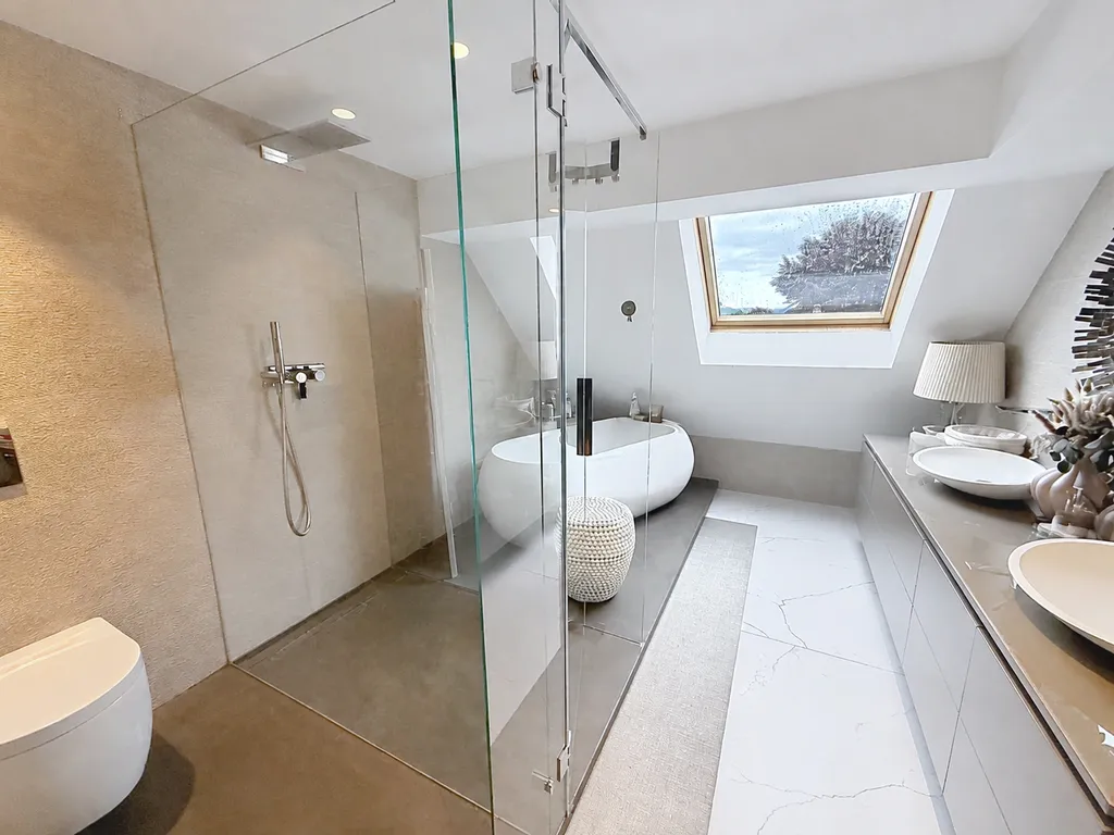 Modernes Badezimmer mit Dachfenster und freistehender Wanne