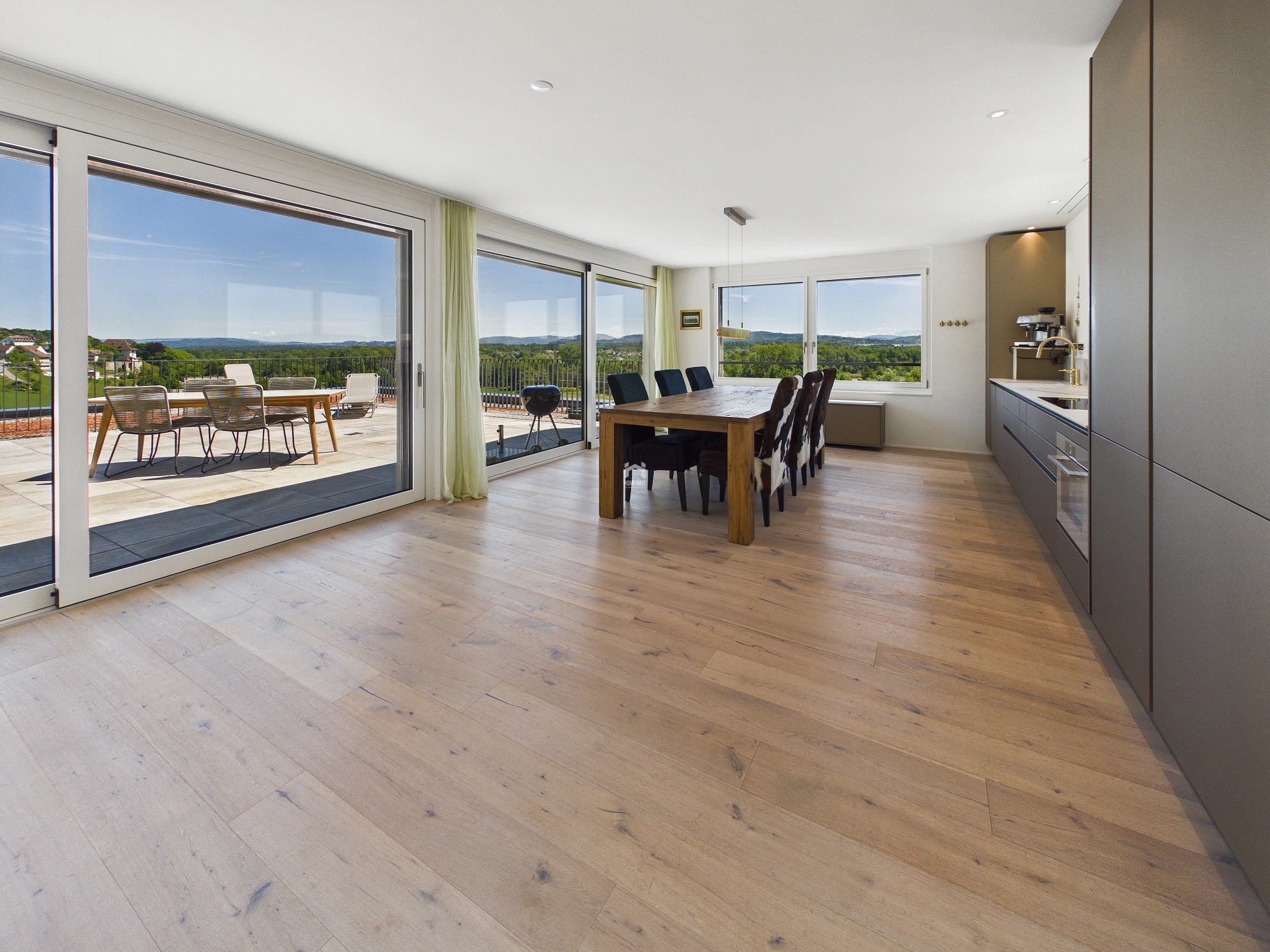 Offener Wohn- und Essbereich mit Terrasse und Panoramablick
