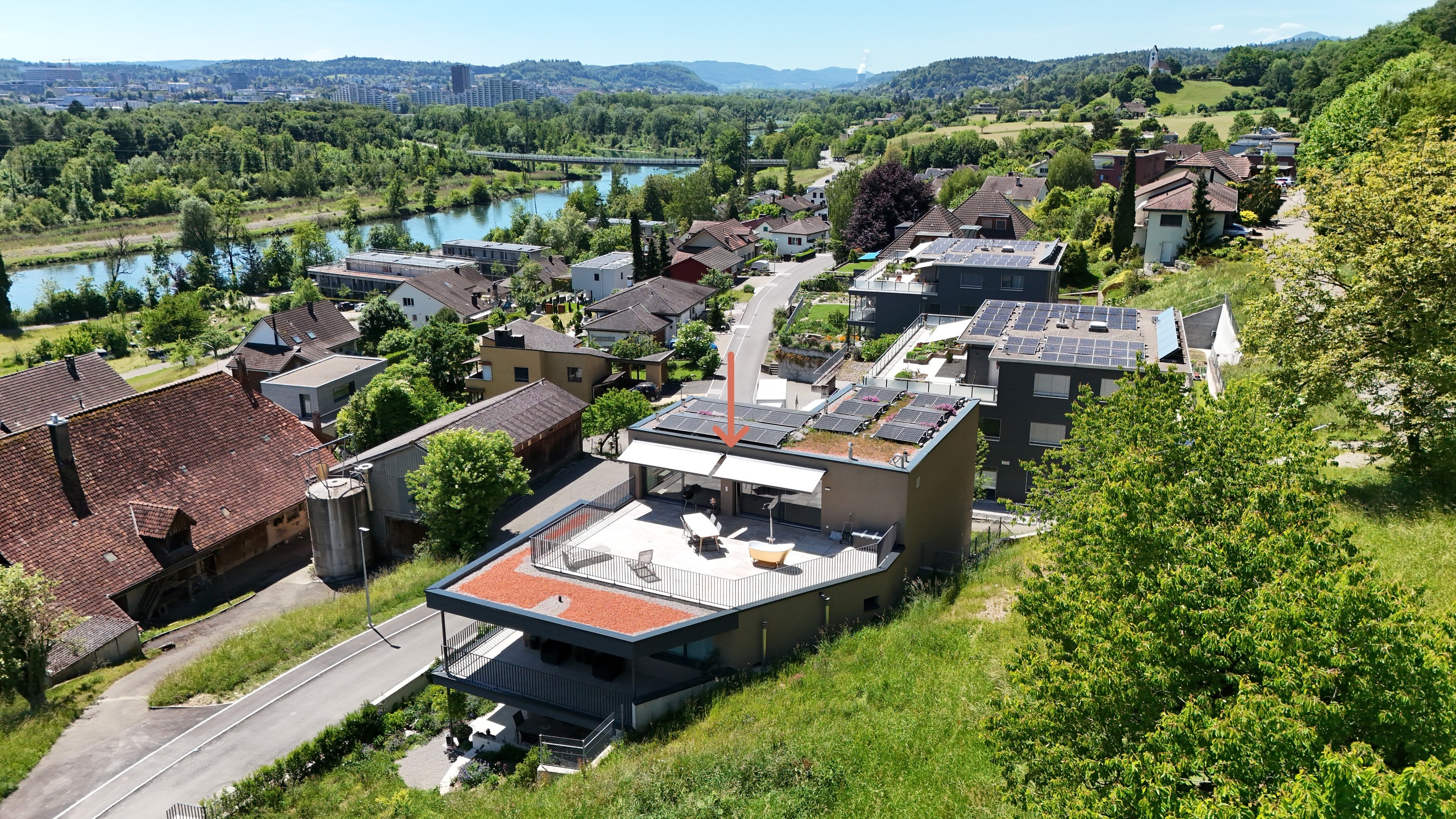 Luftaufnahme eines Wohngebiets mit Villa und Flussblick