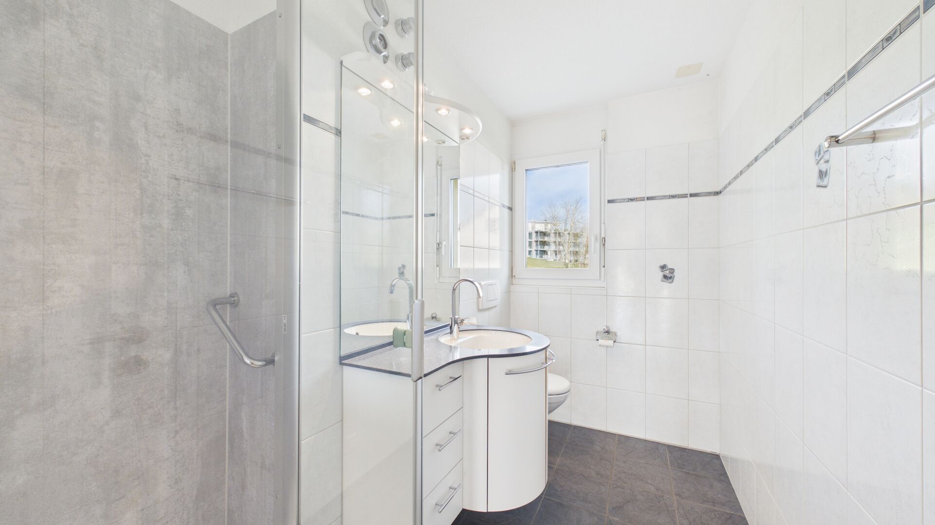 Helles Badezimmer mit Dusche und Fenster