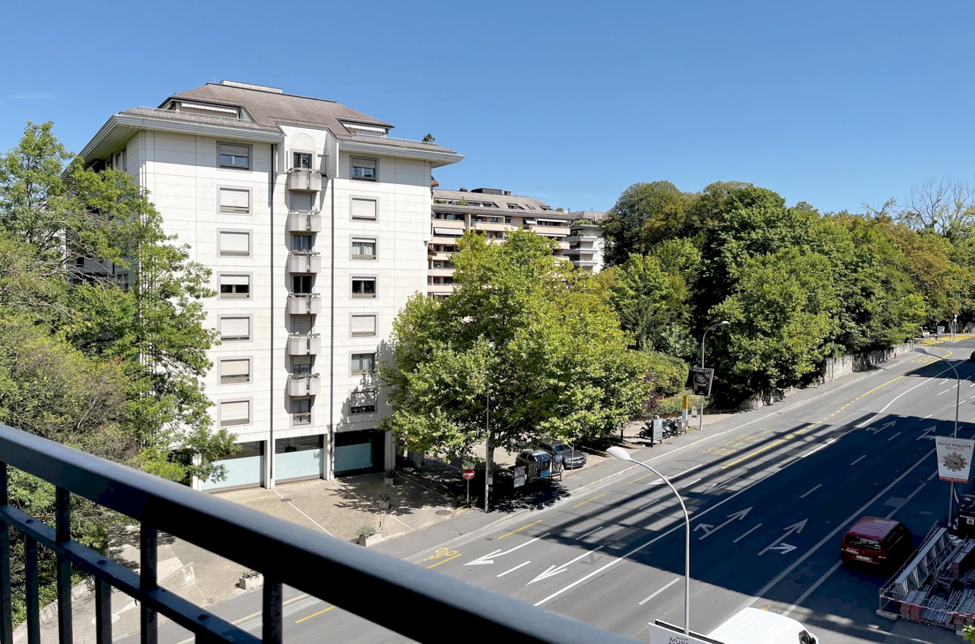 Blick vom Balkon auf eine Stadtstraße und ein Wohngebäude