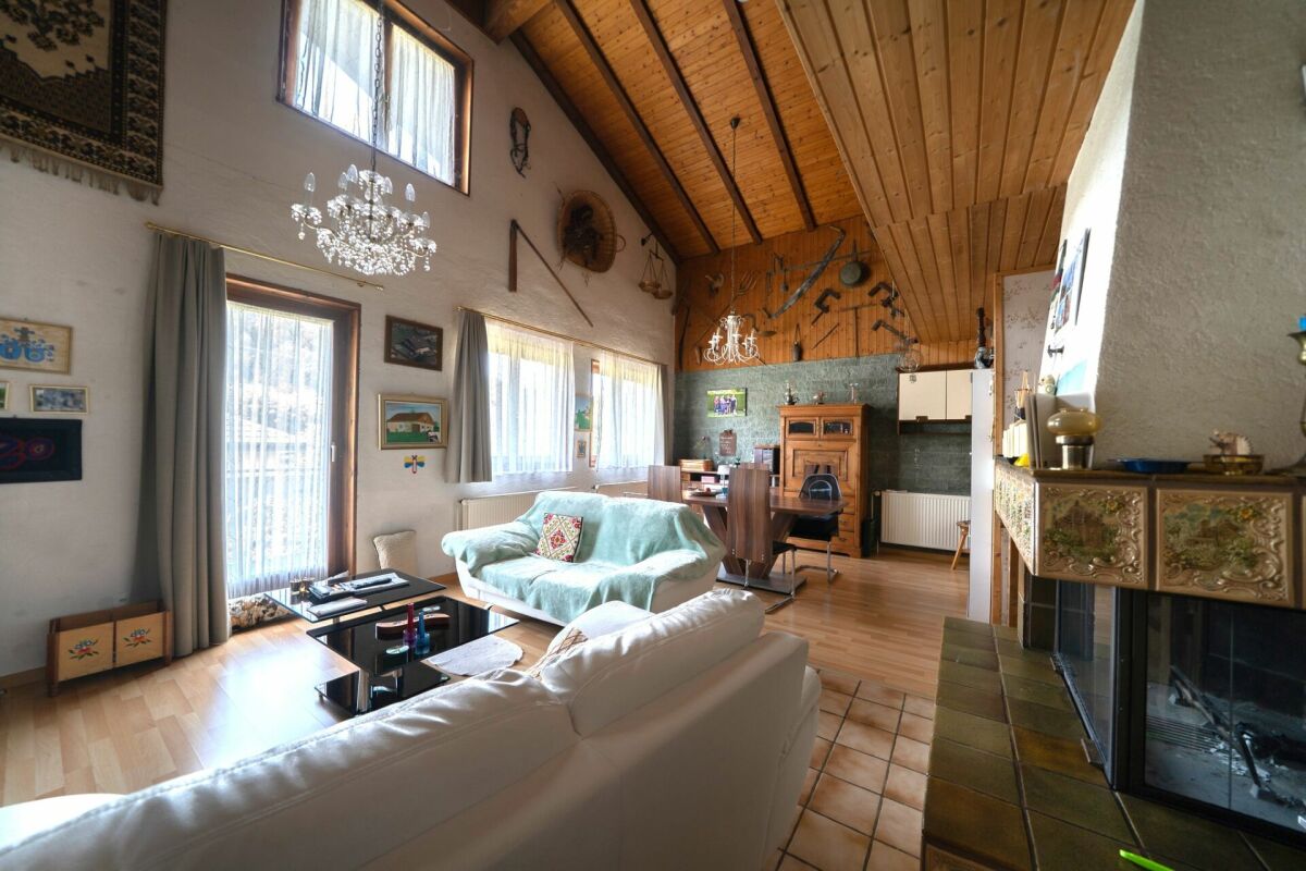 Gemütliches Wohn-Esszimmer mit sichtbarer Holzdecke und Kamin