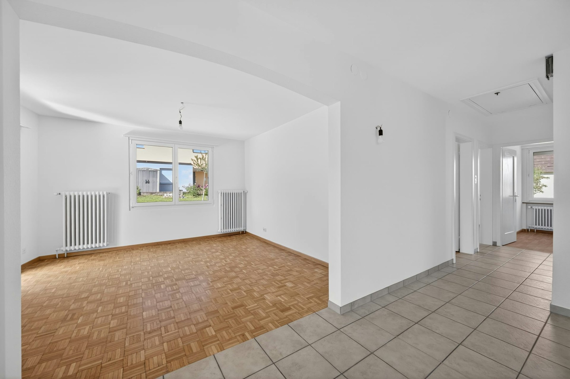 Heller leerer Wohnbereich mit Flur und Blick in den Garten