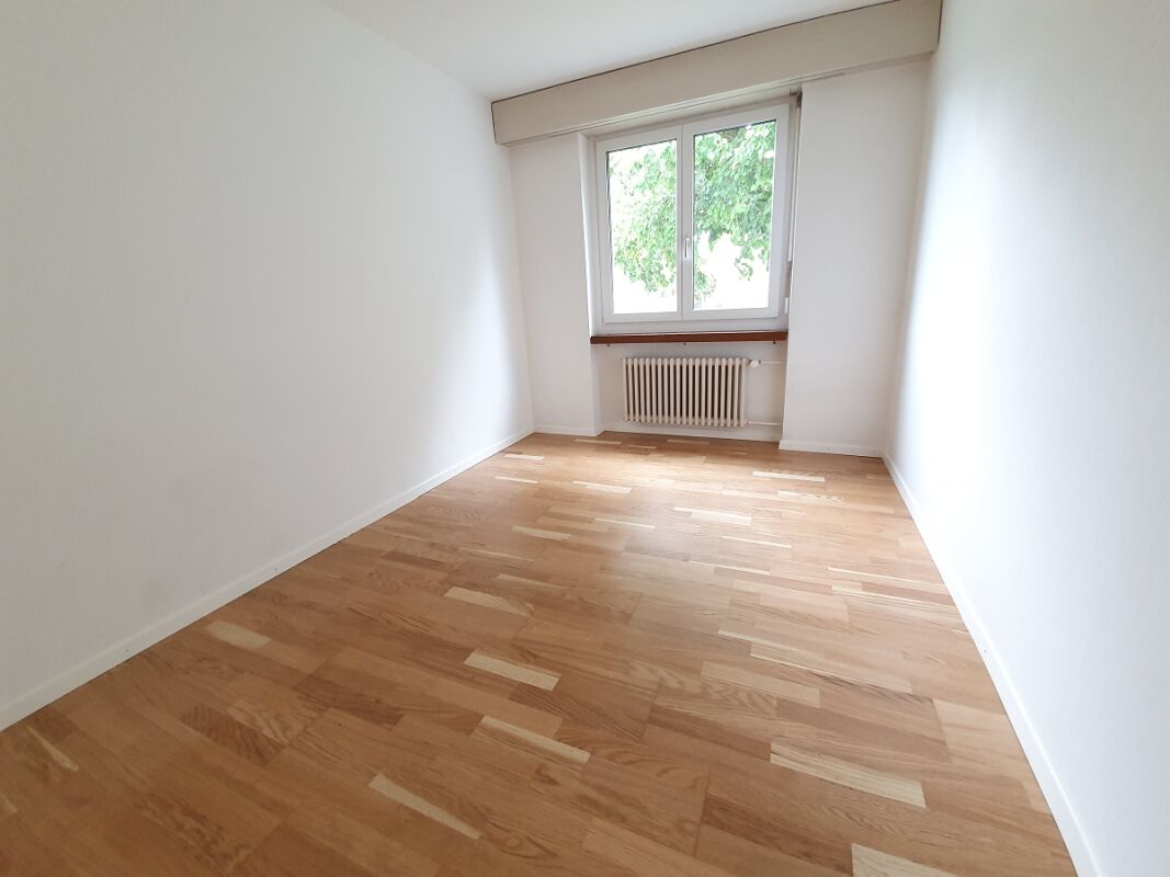 Helles leeres Zimmer mit Parkett und Fenster