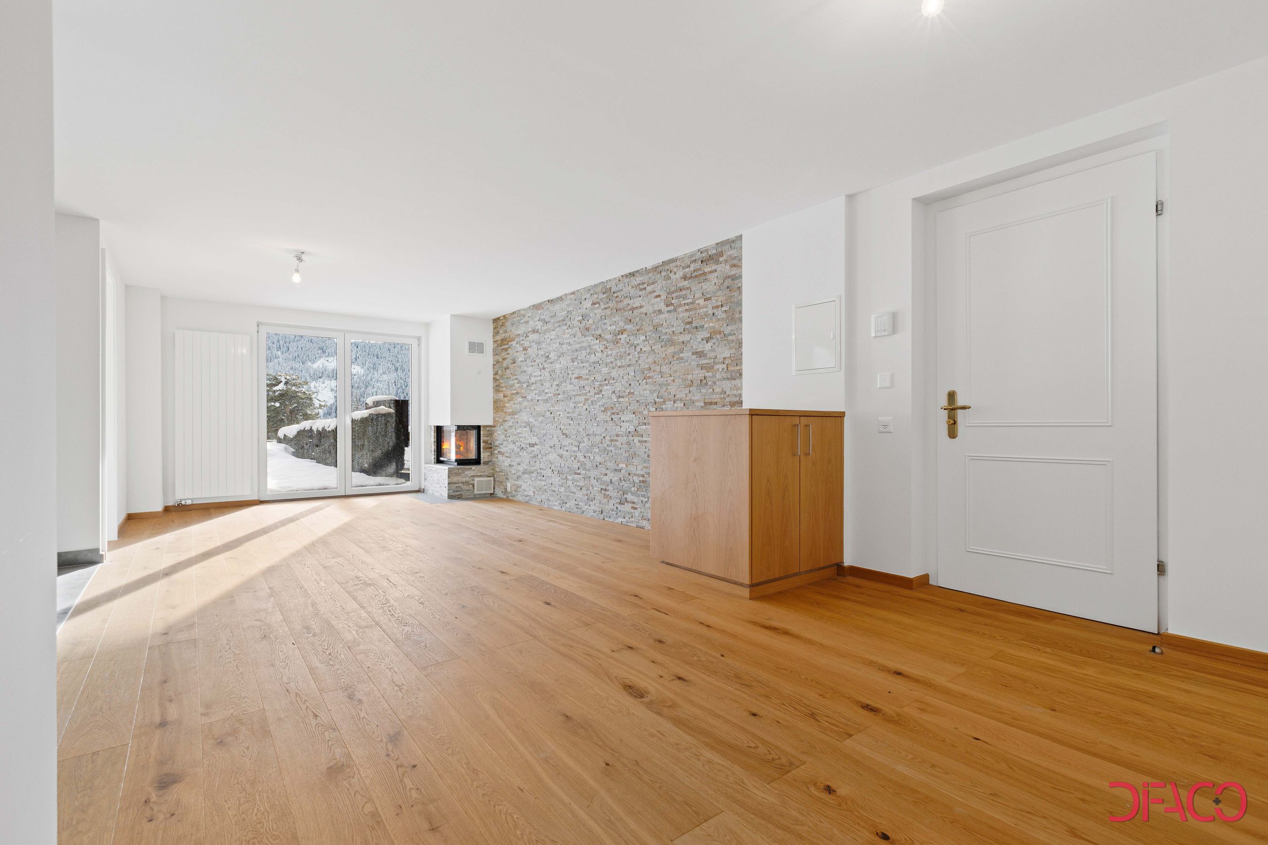 Heller Wohnraum mit Kamin und Bergblick
