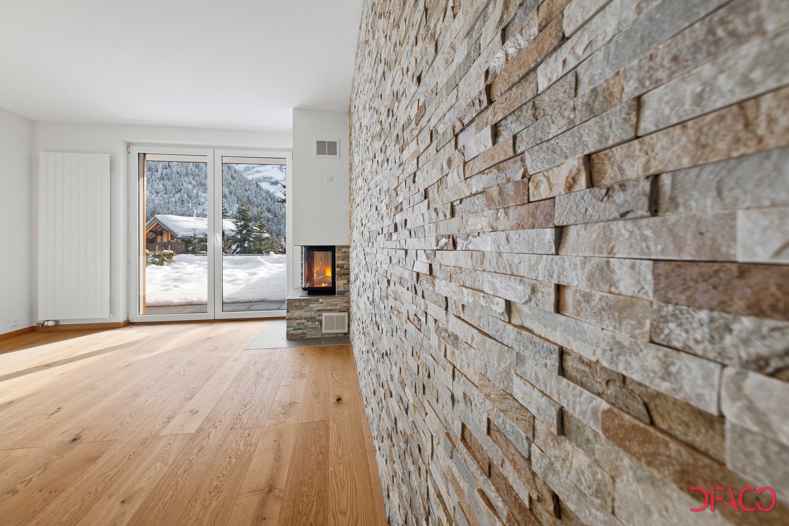 Wohnzimmer mit Natursteinwand und Kamin