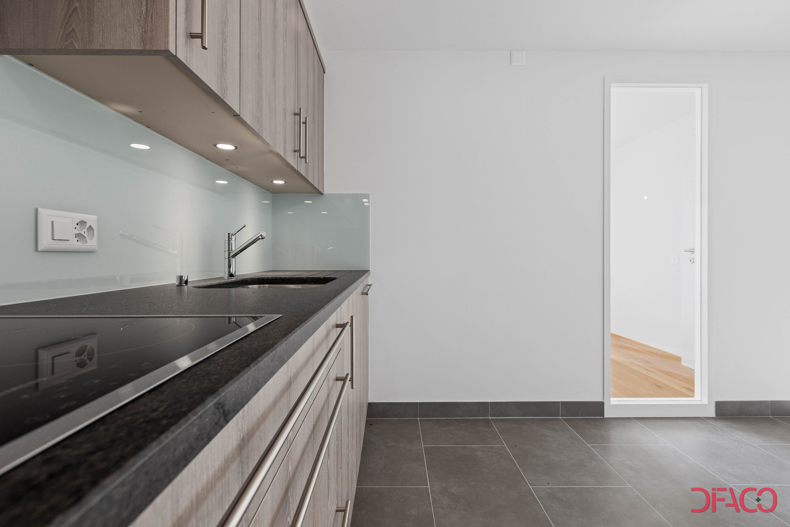 Moderne Küche mit hellem Holz und dunkler Arbeitsplatte
