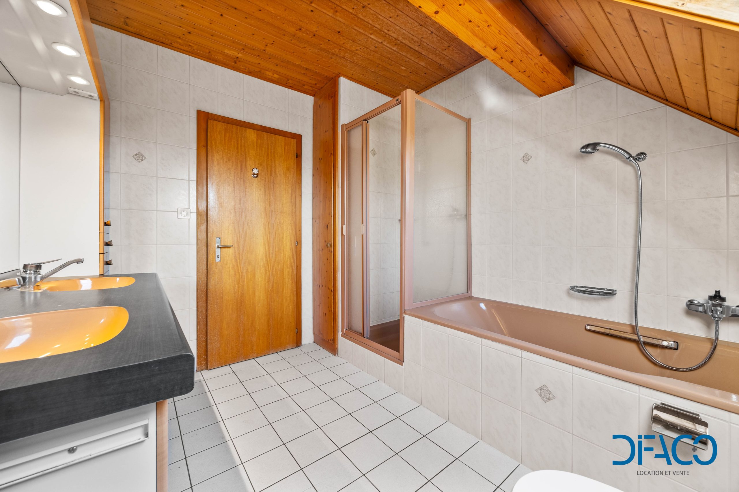 Badezimmer mit Holzdecke und Wanne
