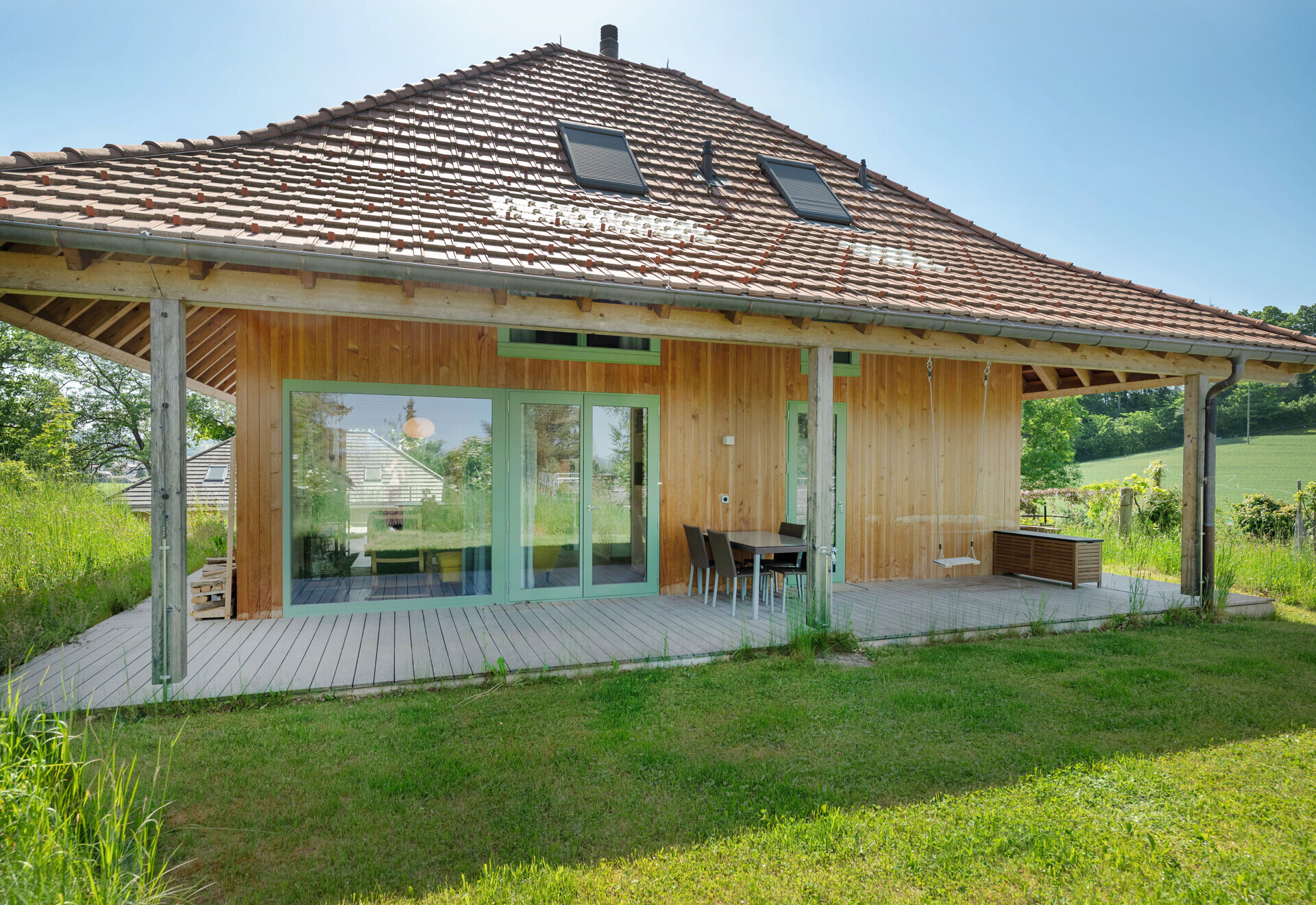 Außenansicht eines Holzhauses mit großer Terrasse