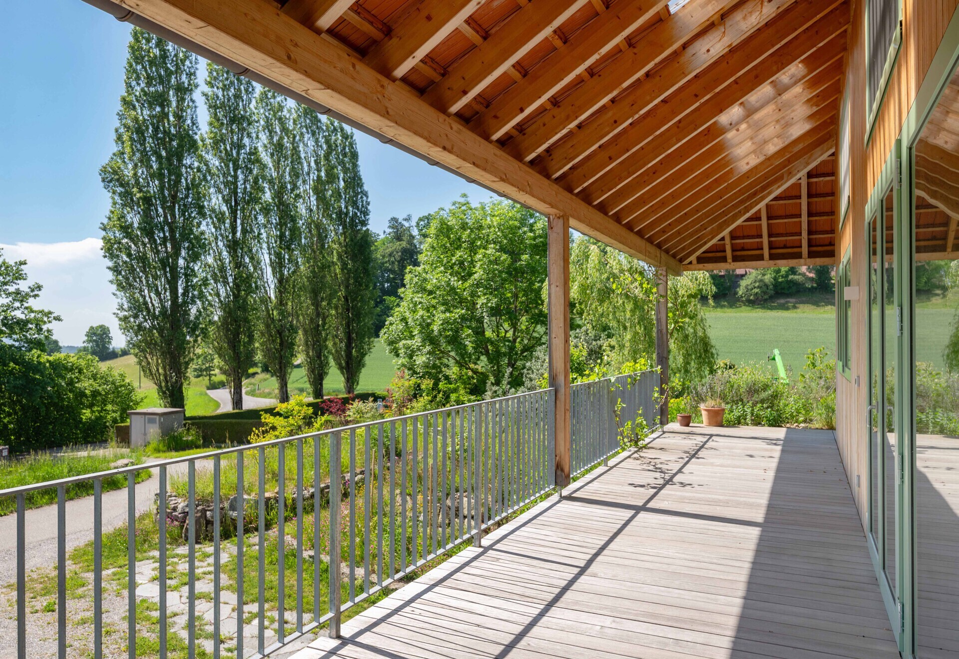 Überdachte Holzterrasse mit Landschaftsblick
