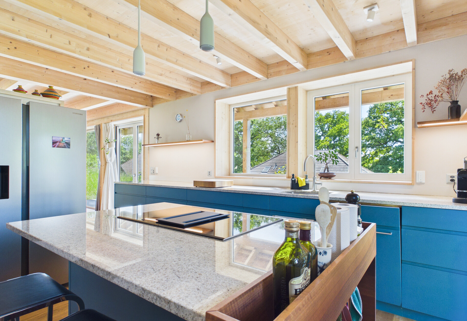 Moderne Küche mit Holzdecke und grünem Ausblick