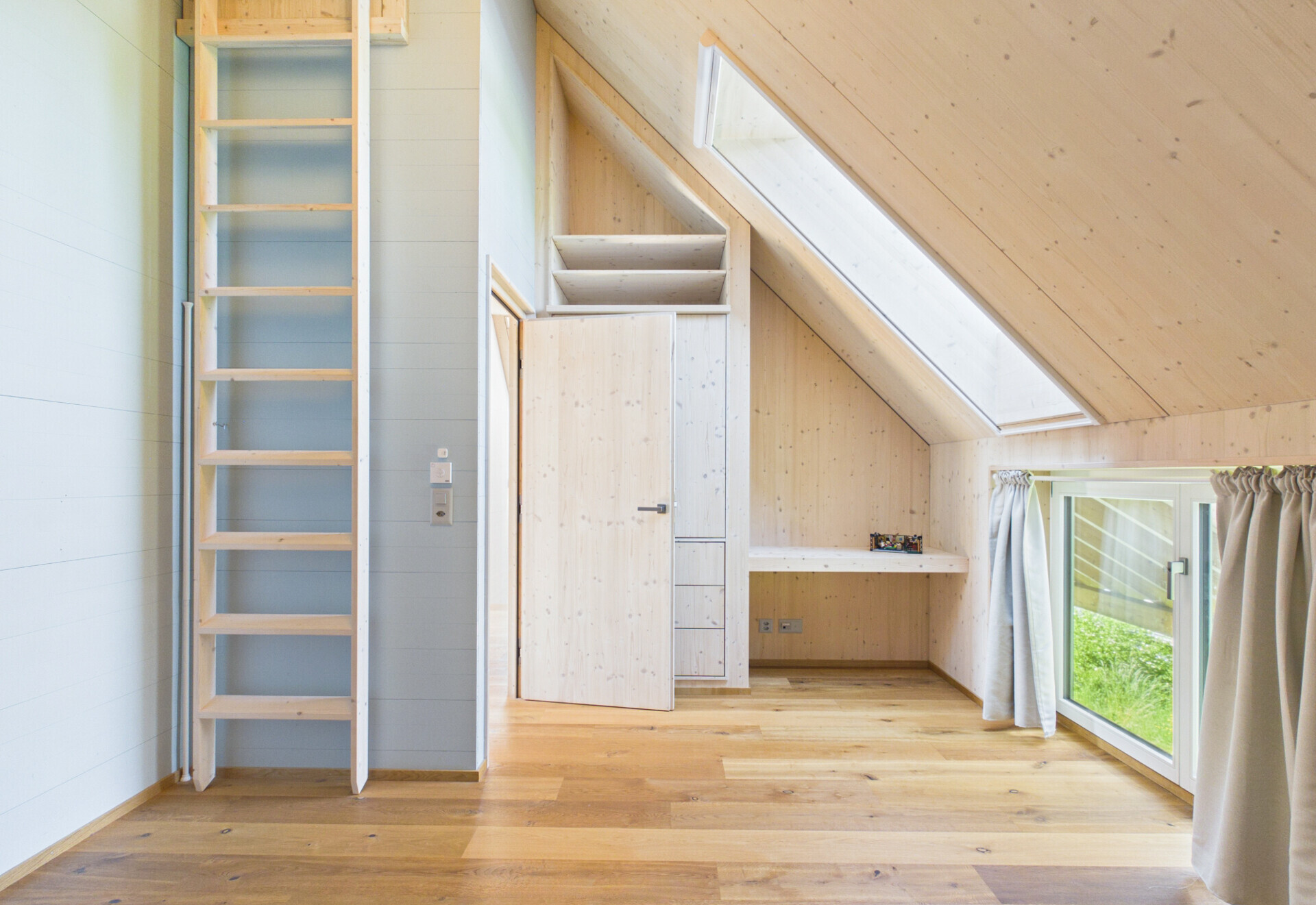Helles Dachgeschosszimmer mit Dachfenster und Leiter