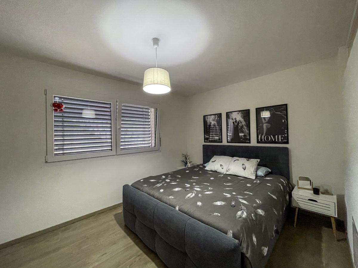 Schlafzimmer mit Doppelbett und Fensterrollläden