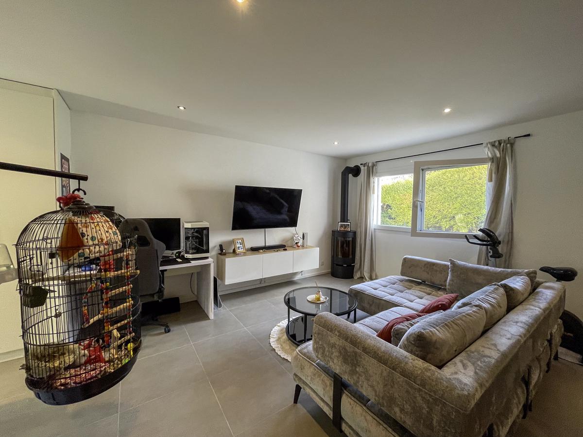 Wohnzimmer mit grauem Sofa und TV-Bereich