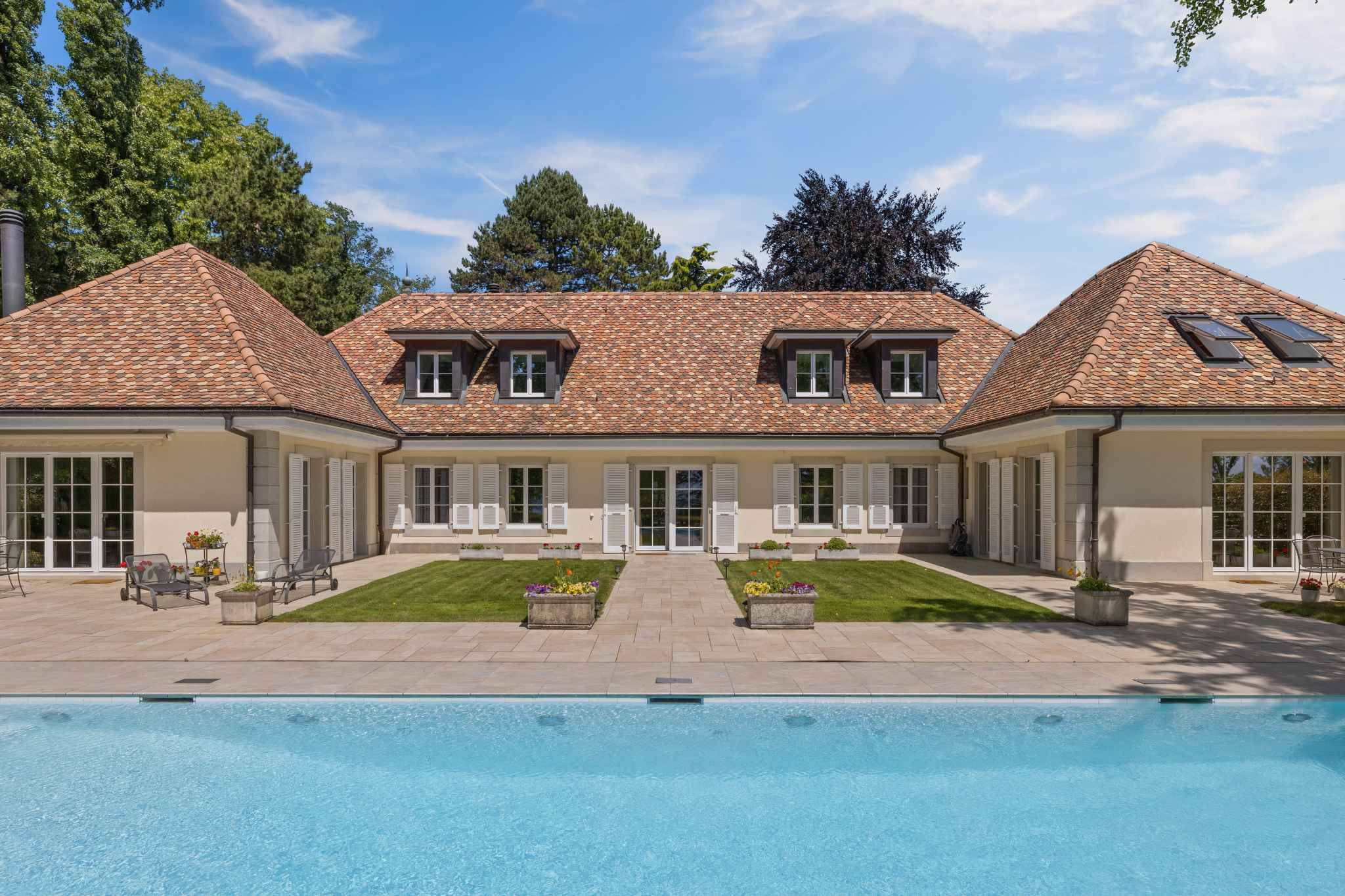 Luxuriöse Außenansicht mit Pool und Innenhof