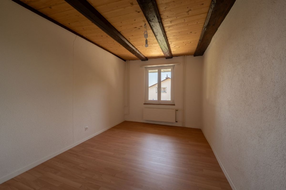 Leerer Raum mit Holzbalkendecke und Fenster