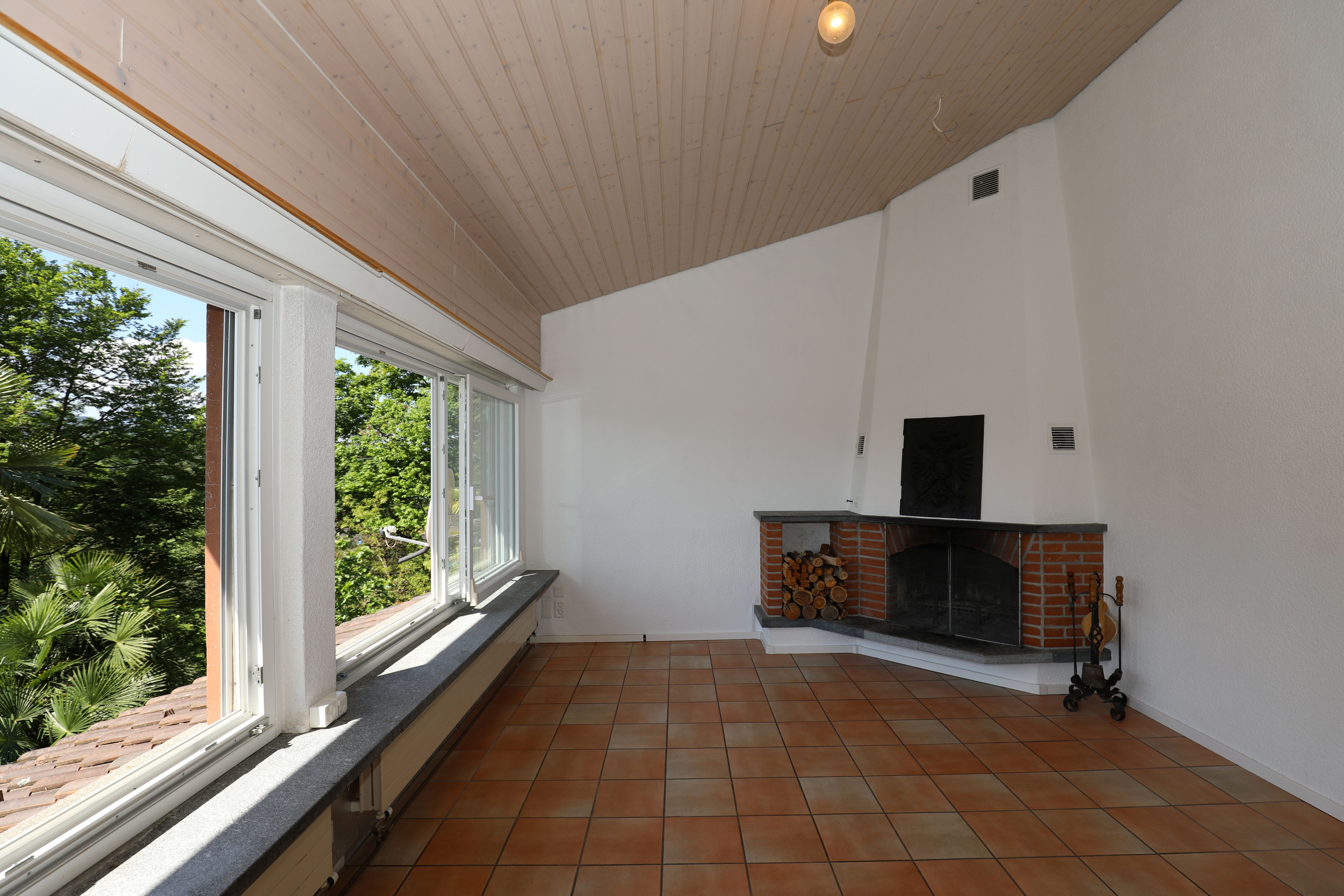 Wohnraum mit Kamin und Panoramafenstern